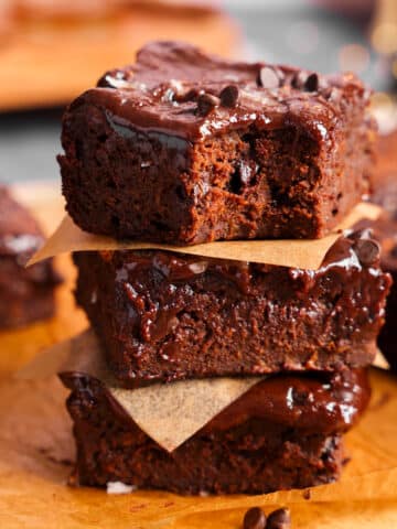 Healthy vegan sweet potato brownies with a fudgy texture and shiny chocolate glaze, stacked in a close-up food photography shot