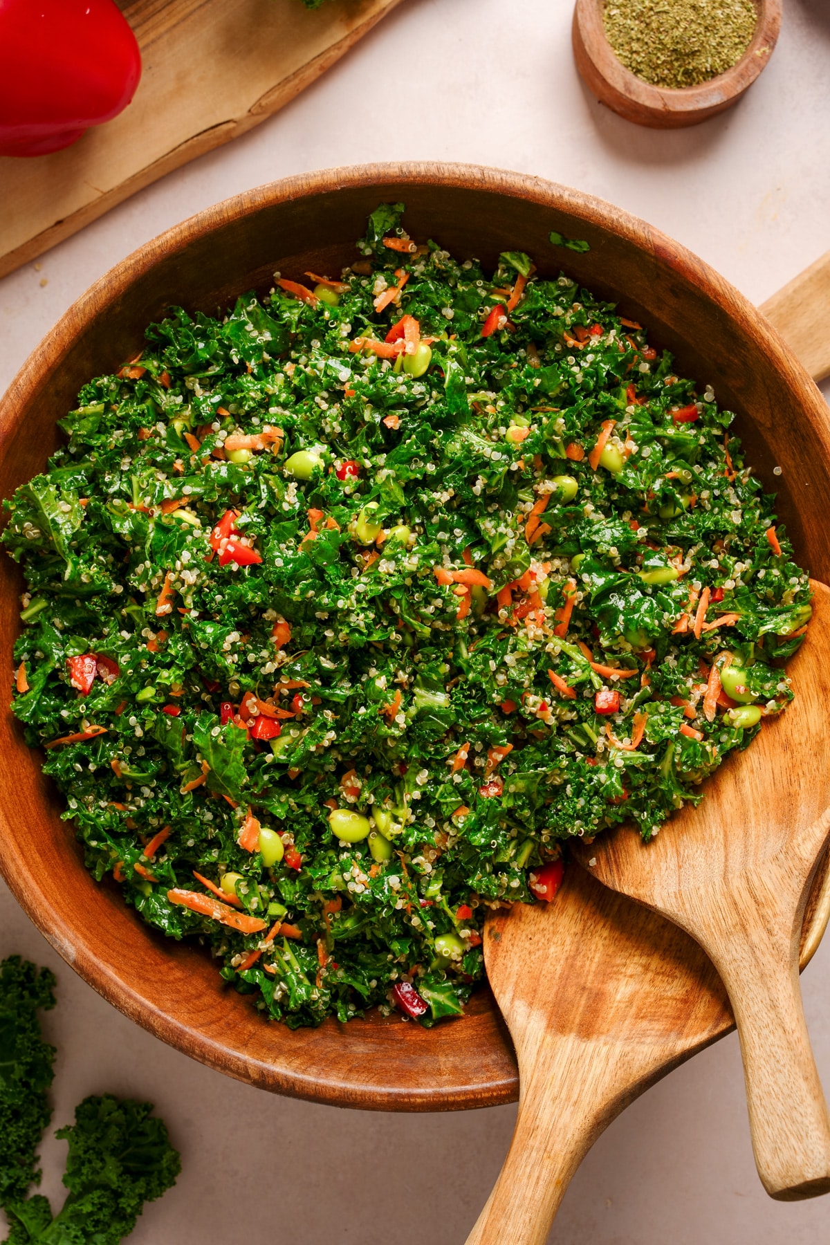 looking down at the rainbow kale salad in a wooden bowl with the