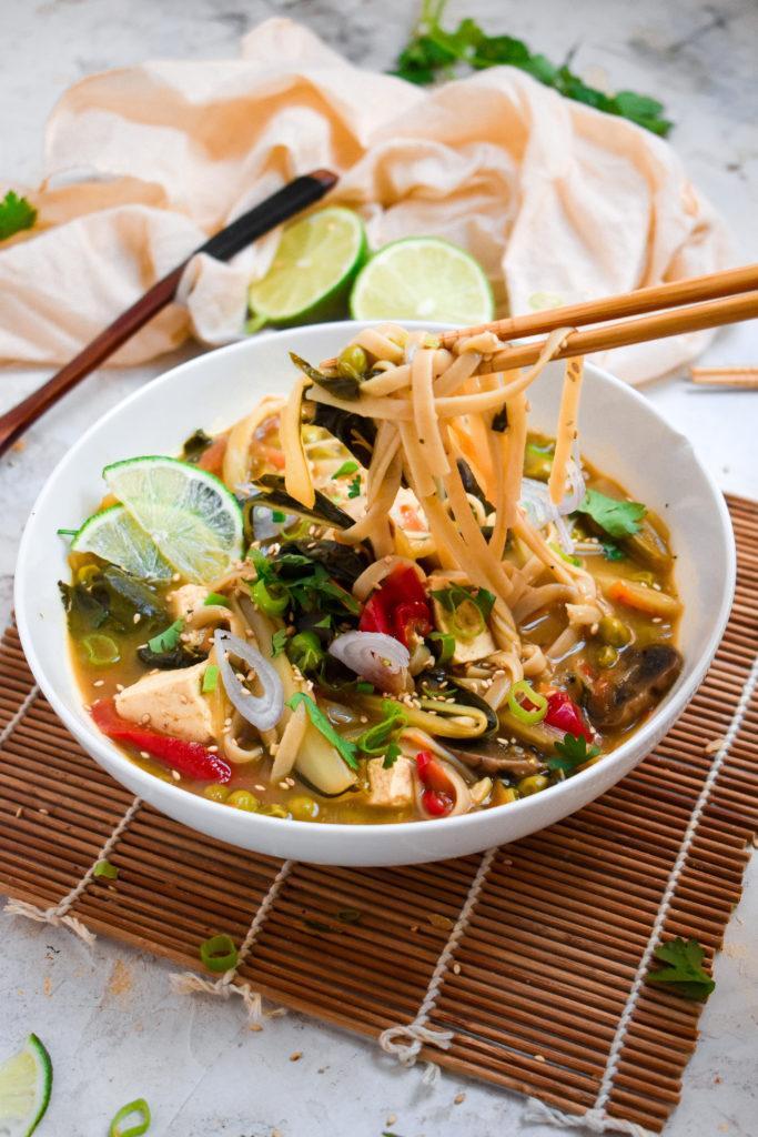 thai green curry ramen with chopsticks picking up the gluten-free noodles