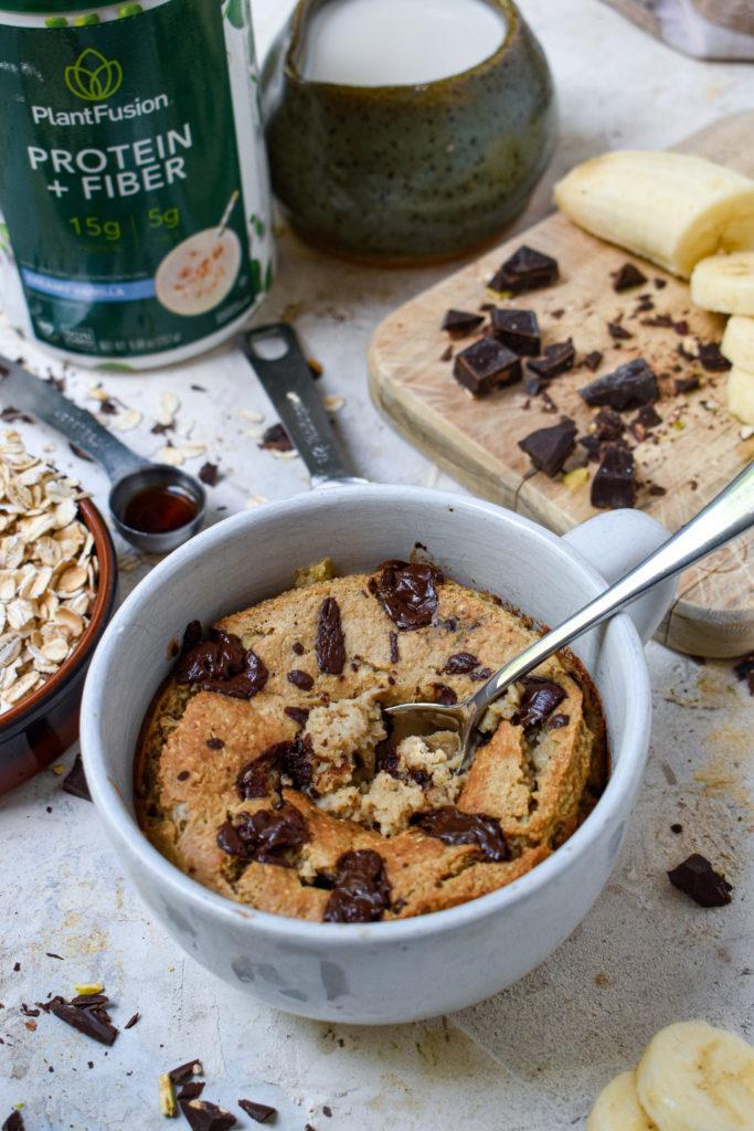 chocolate banana baked oats with the protein powder and other ingredients around the finished product.