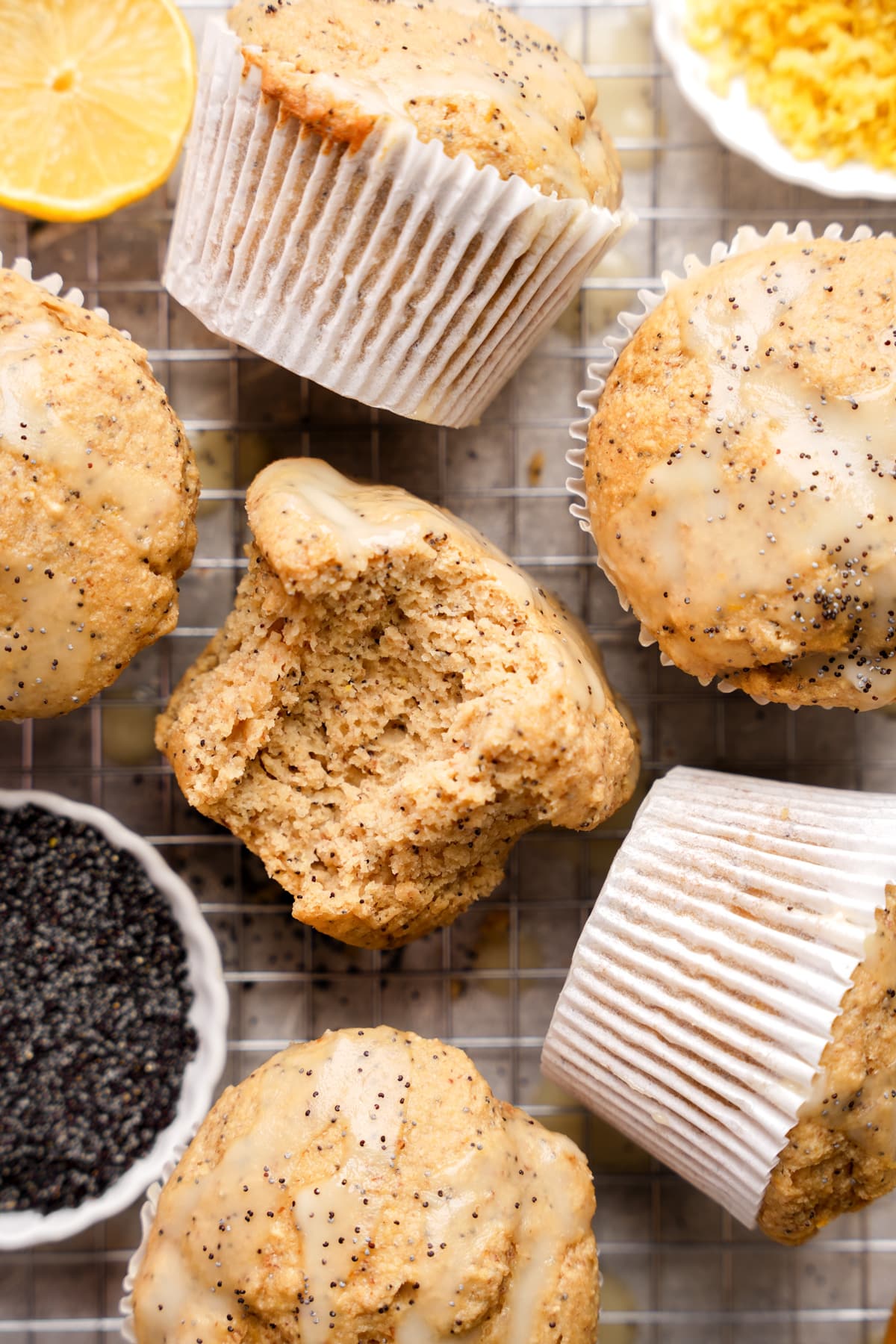 looking down at the vegan lemon poppy seed muffins with a bite taken out of one to show the fluffy texture