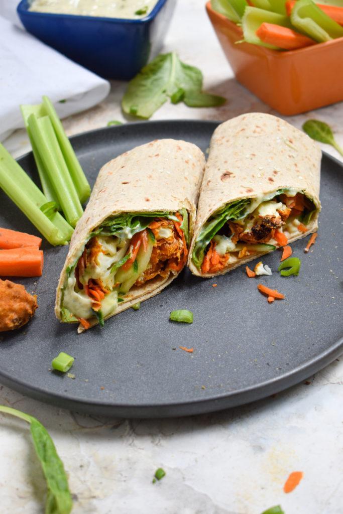 buffalo cauliflower wrap cut in half to show the crispy oil-free buffalo cauliflower bites