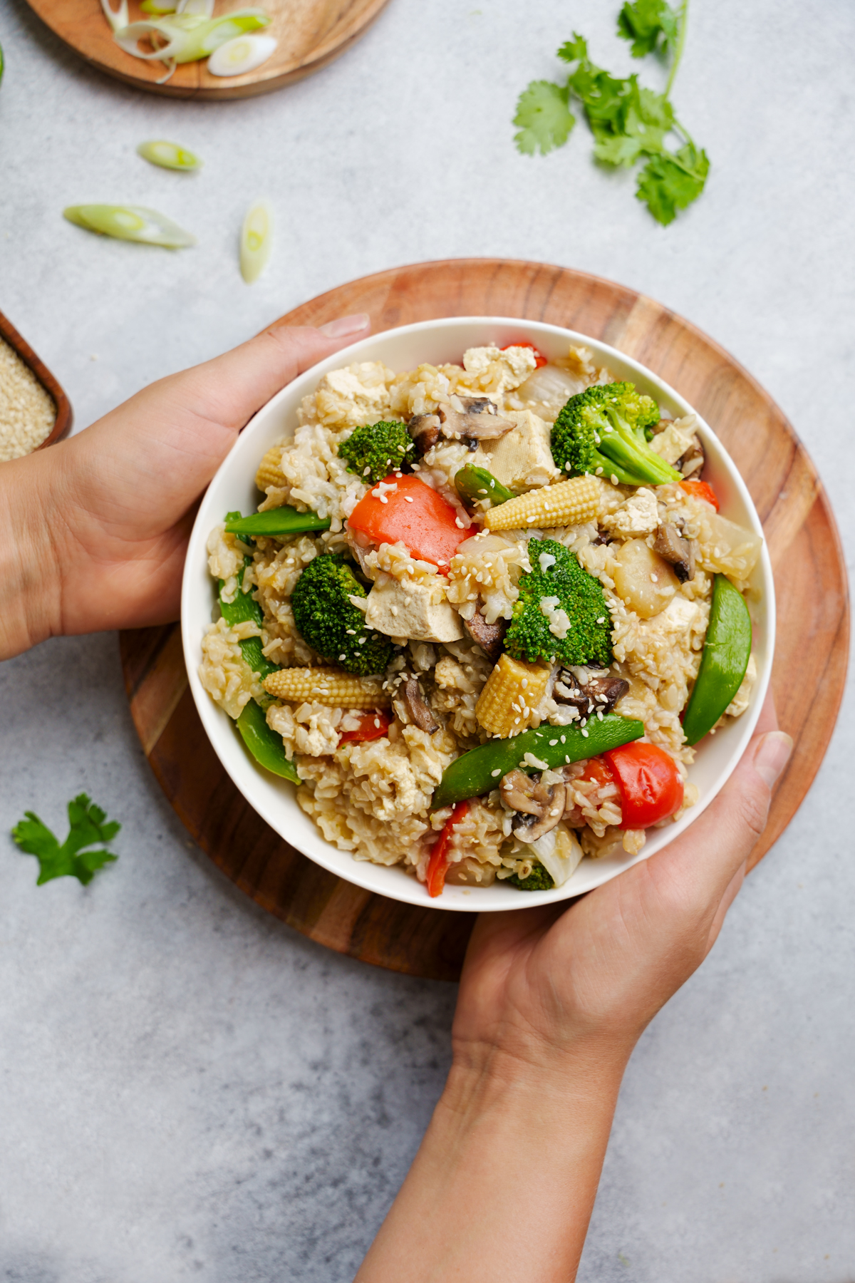 the easy vegan fried rice with hands holding the bowl