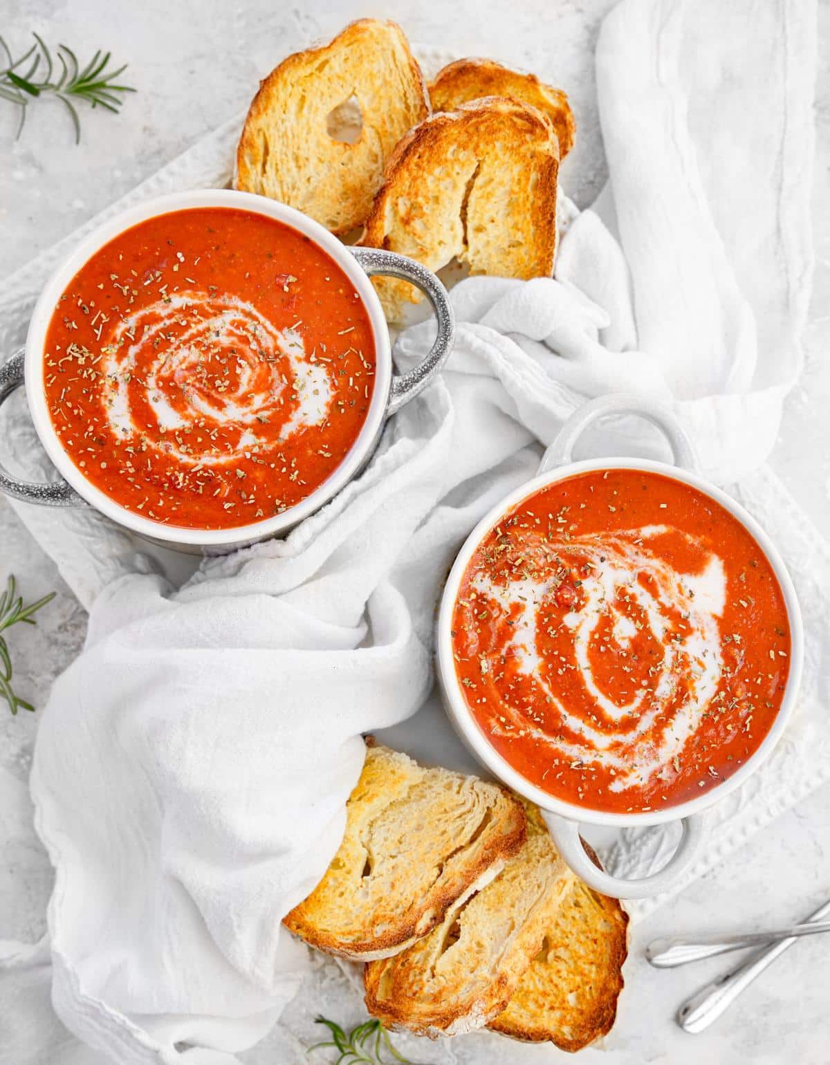 two bowls of the whole foods plant based recipe with bread and fresh herbs
