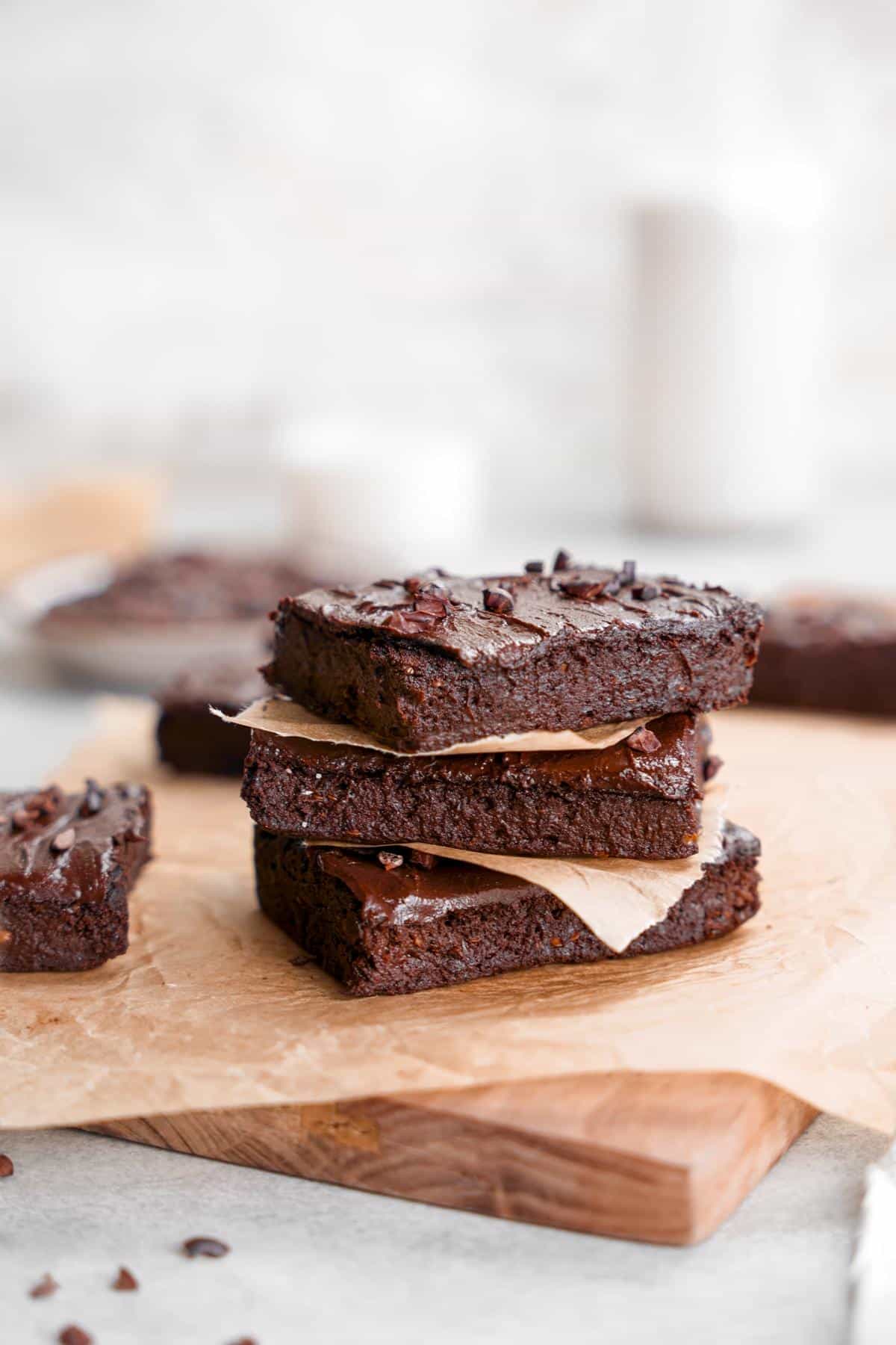 the eggplant brownies tacked on top of each other with chocolate frosting and cacao nibs