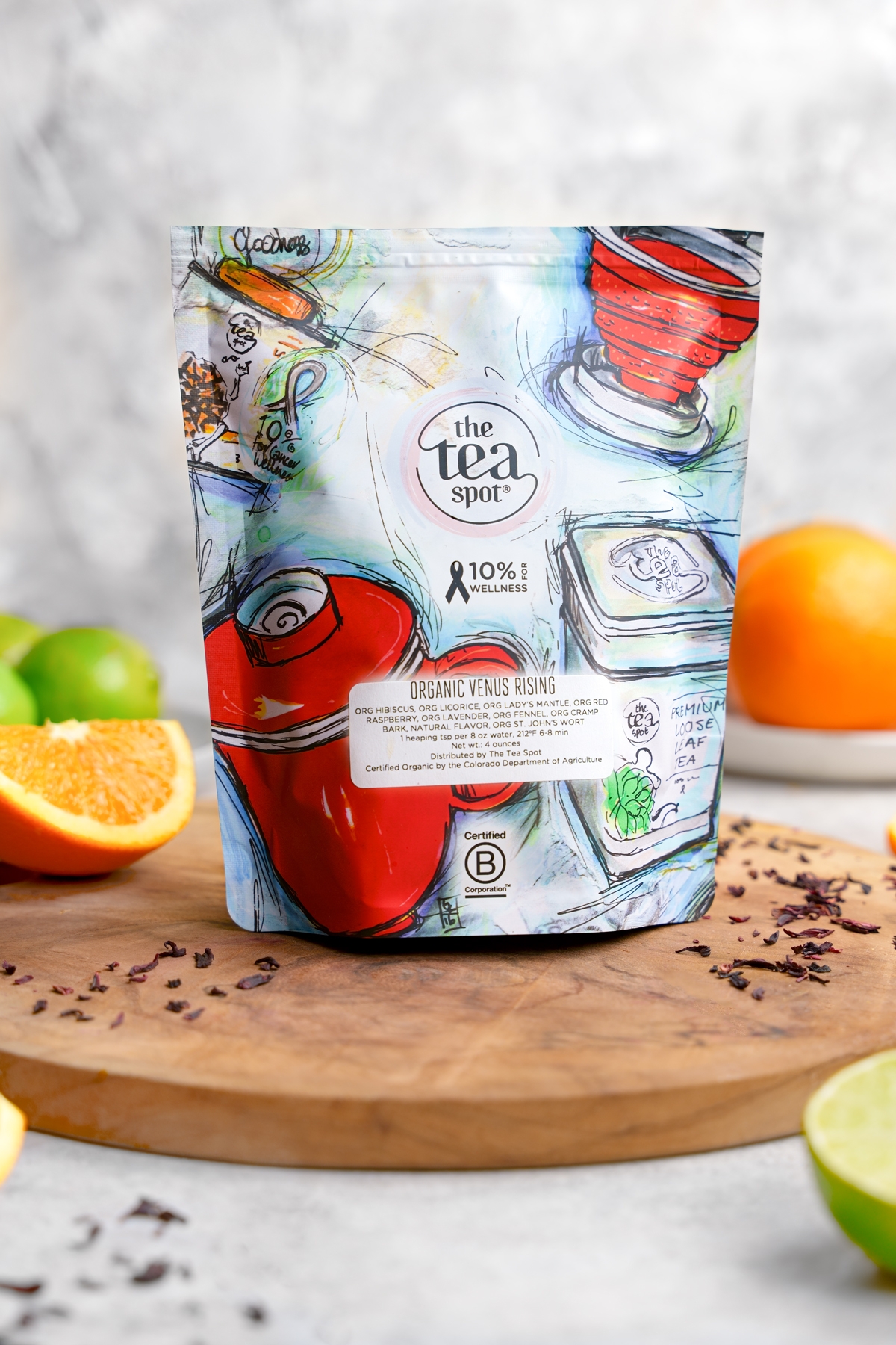 the bag of organic venus rising tea with the oranges and limes around it