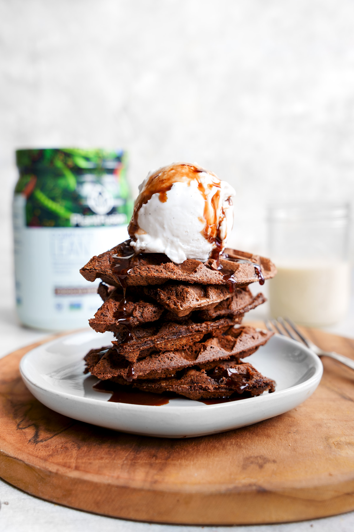 the brownie waffles stacked on top of each other with ice cream and chocolate syrup on top