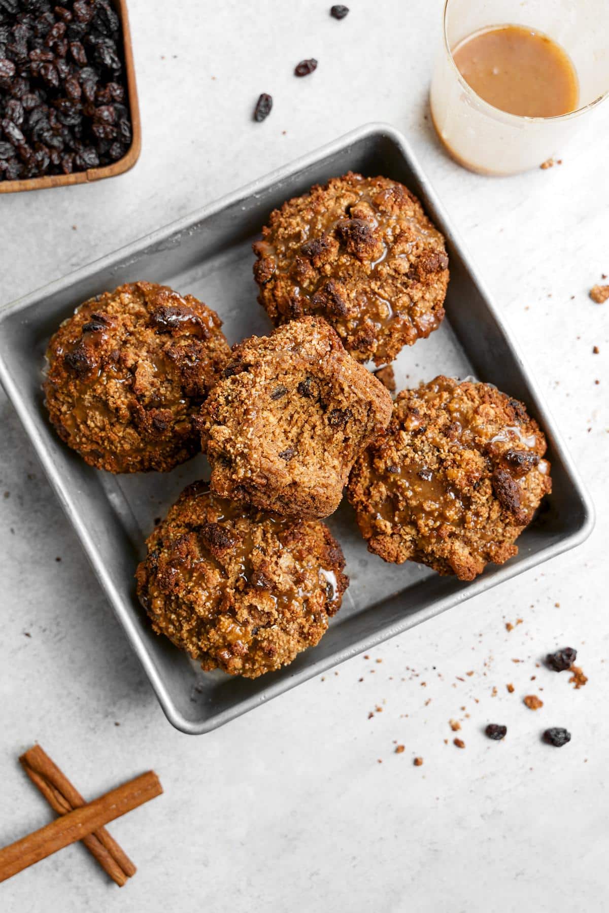 the cinnamon raisin muffins in a square ton with a bite taken out of one