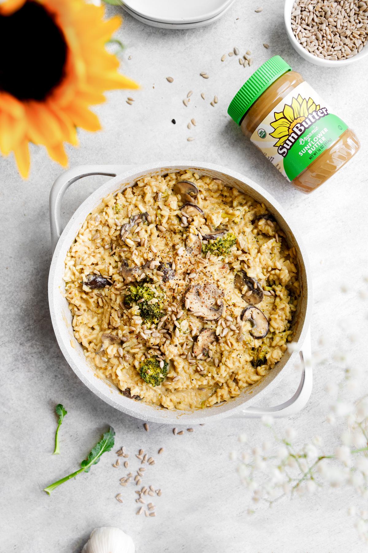 the sunflower risotto in a pot with the sunbutter next to it