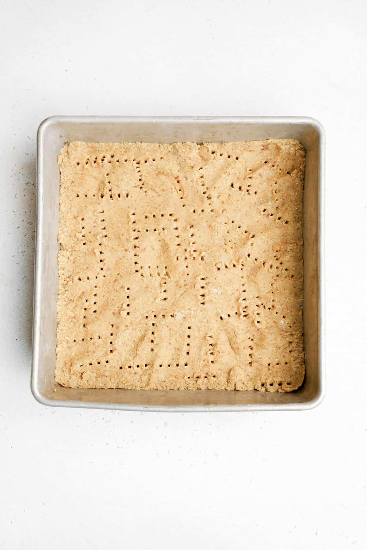 pressing the crust into the baking dish
