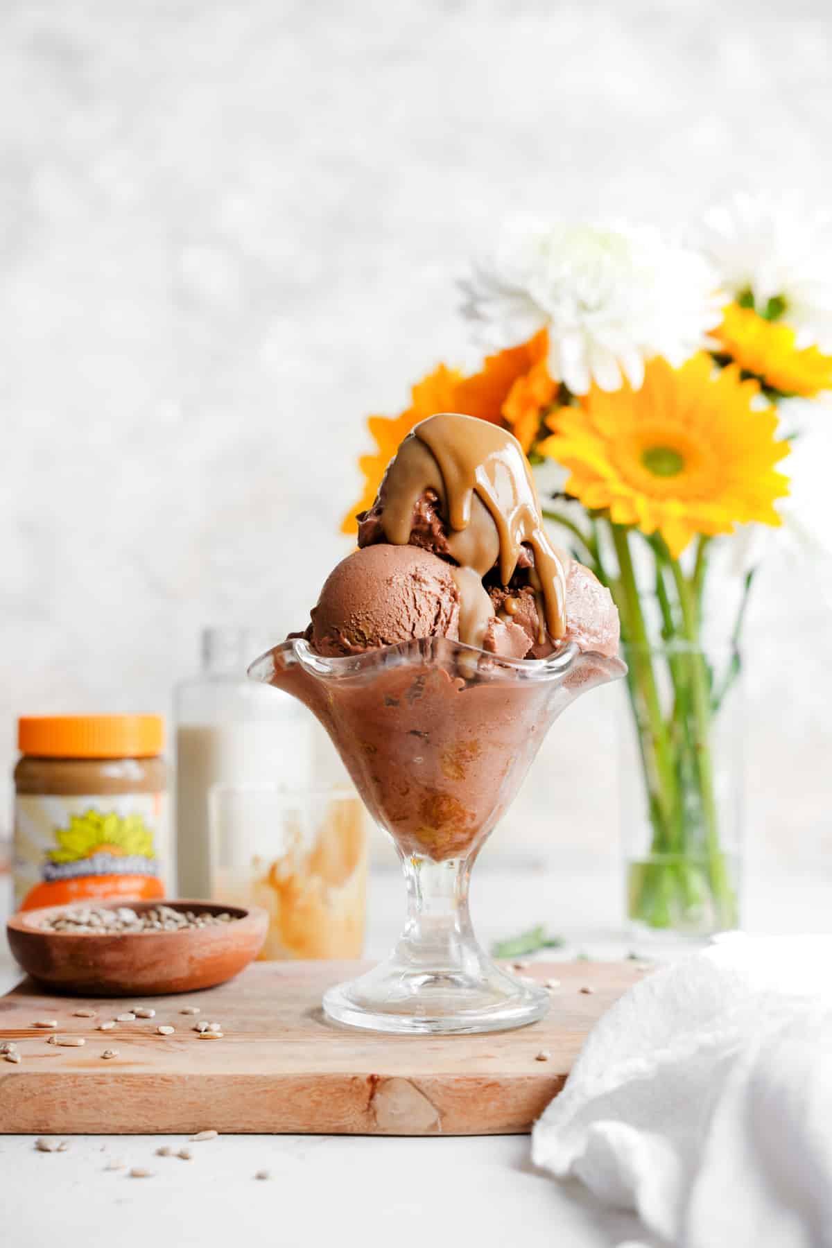 the sunflower ice cream in a ice cream cup with the sunbutter dripping