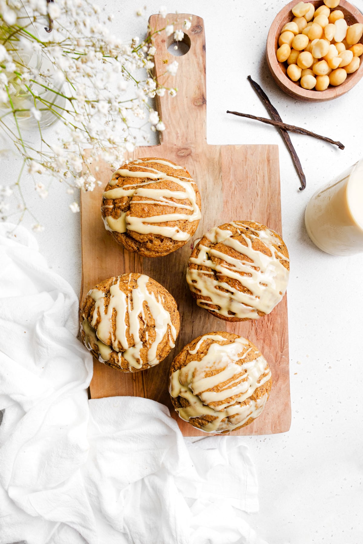 looking down at the vanilla muffins with the glaze on top and fresh vanilla beans next to them