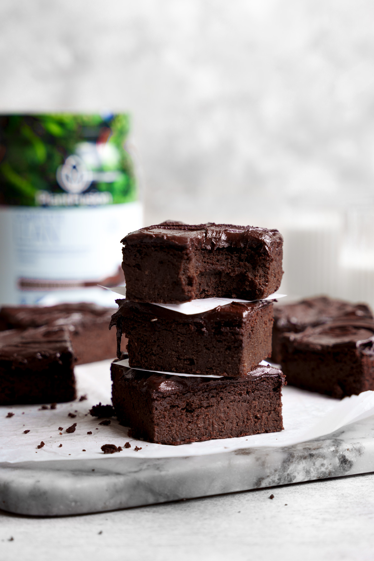 the vegan protein brownies stacked on top of each other with a bite taken out of one