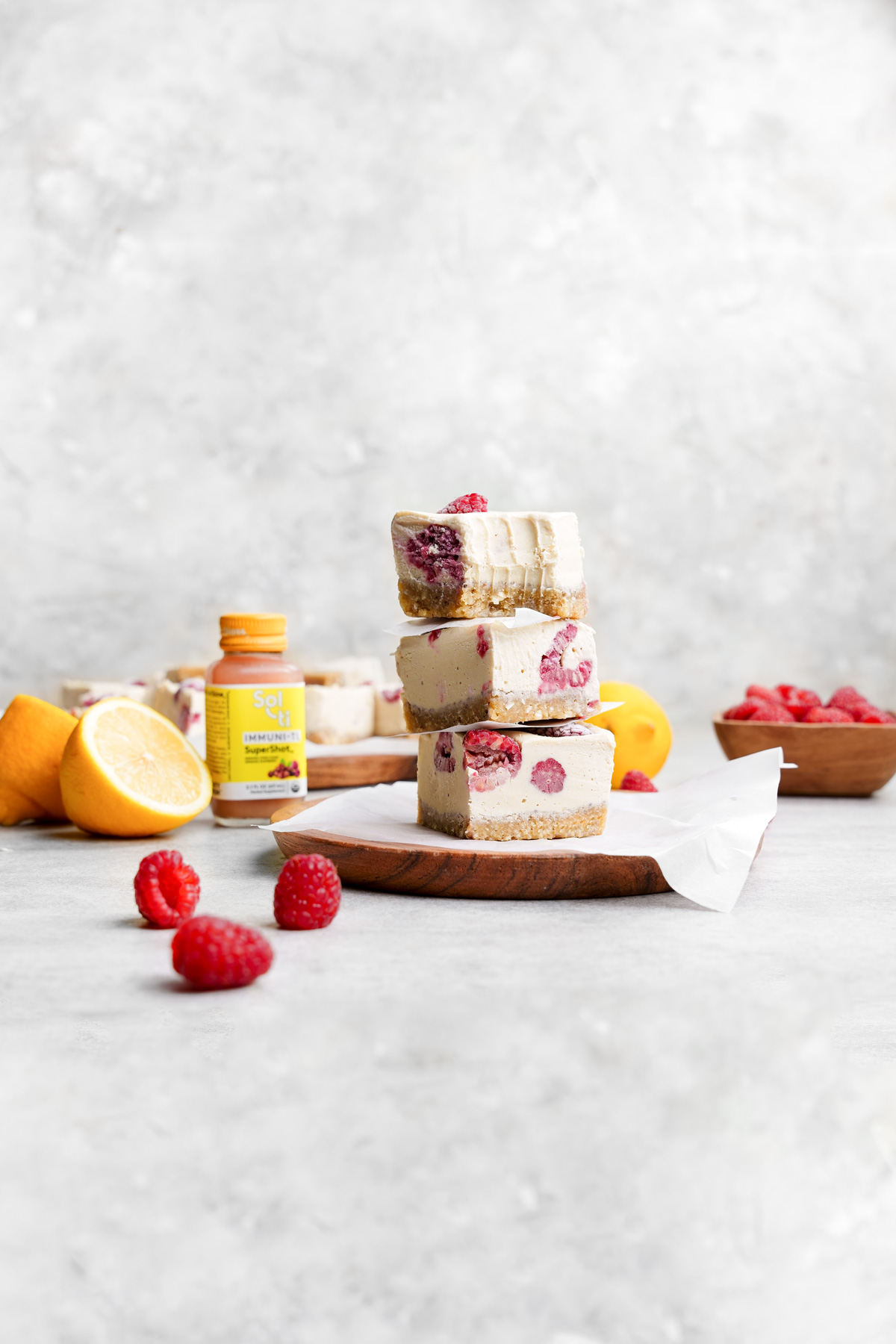 the raw vegan lemon bars stacked vertically with the sol-ti bottle