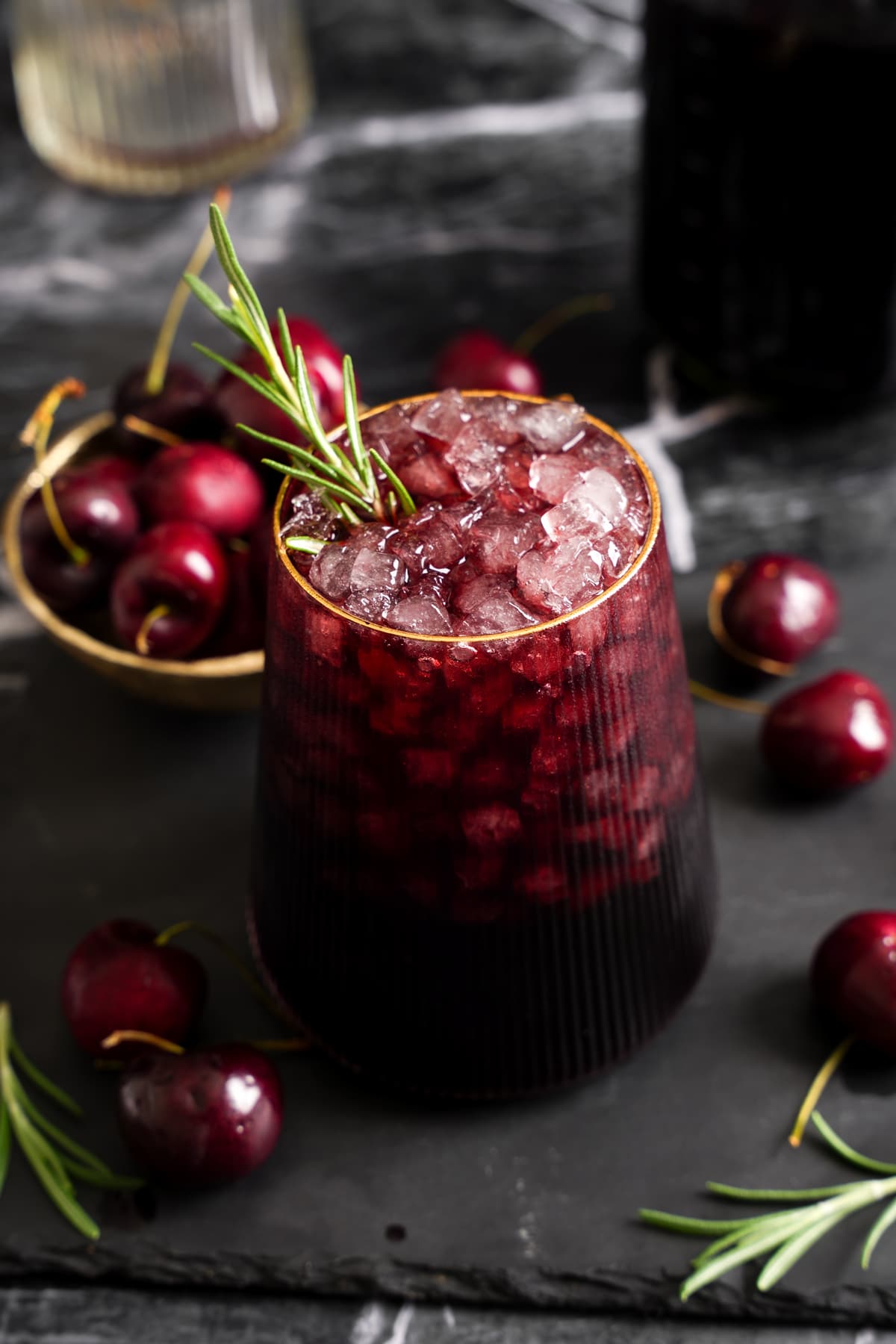Sleepy Girl Mocktail made with tart cherry juice, dark cherry juice, maple syrup, and Dream Elixir served over crushed ice with fresh rosemary.