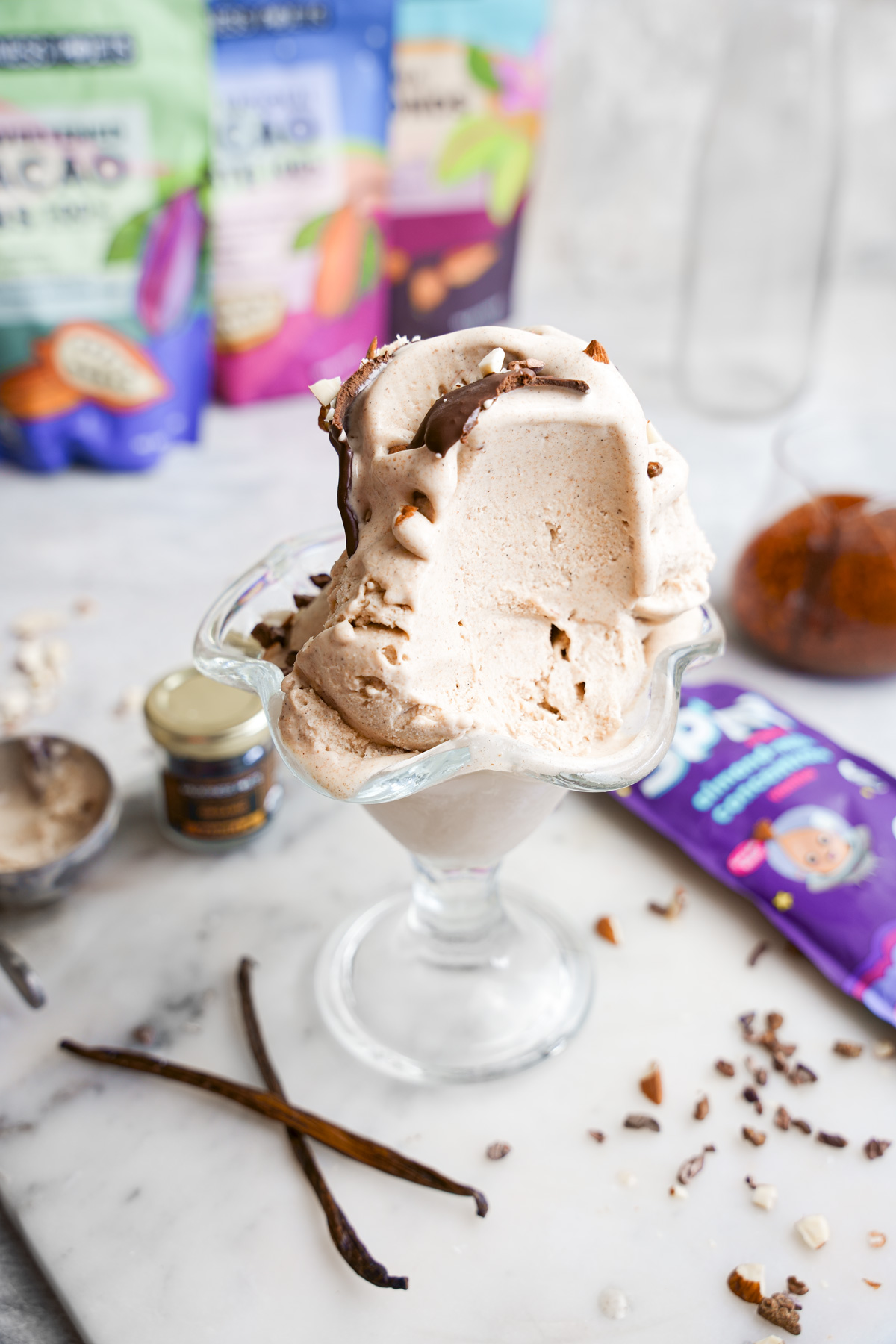 the vegan vanilla ice cream with a scoop taken out of it to show the creamy texture
