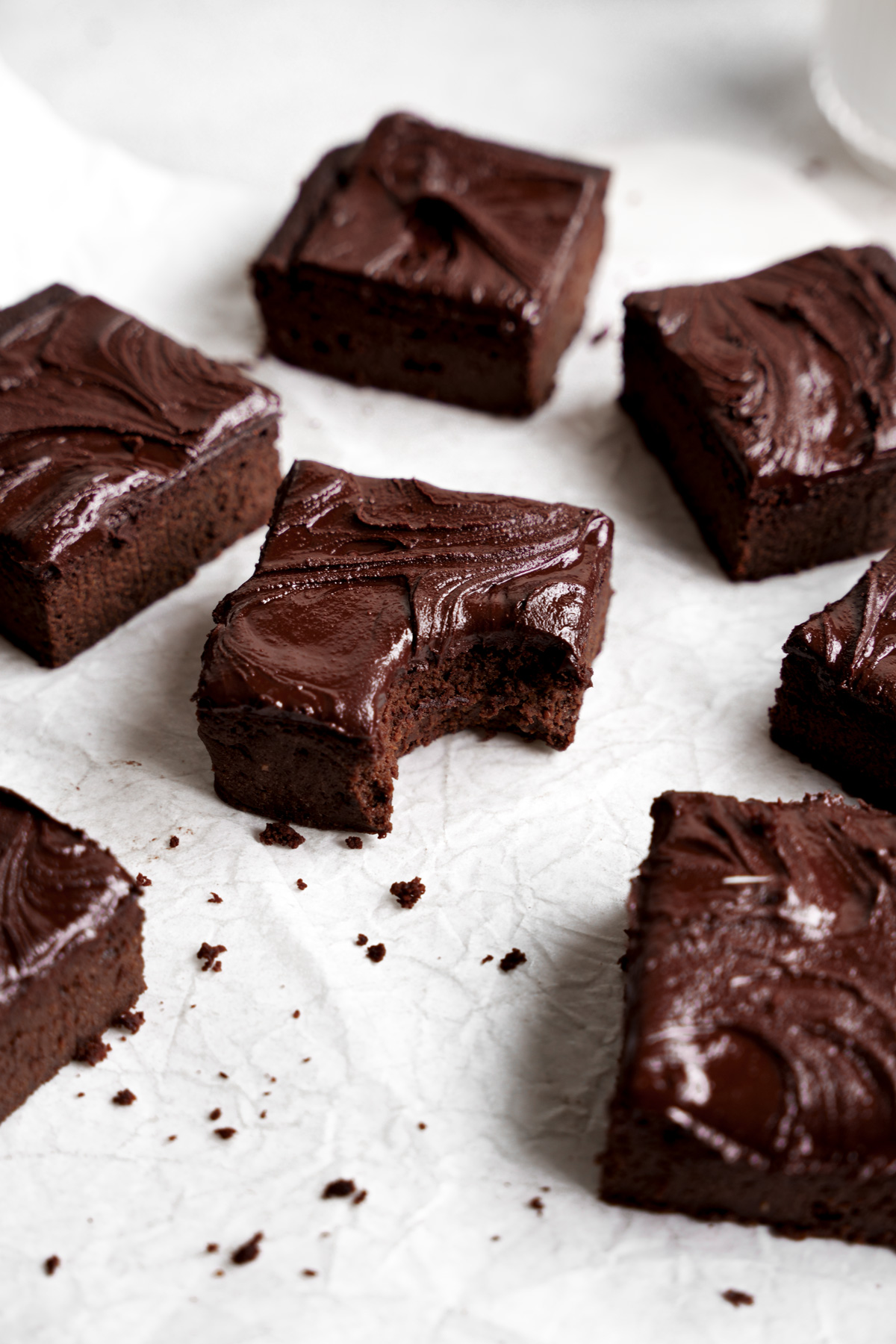 the protein brownie on parchment paper with a bite taken out of one