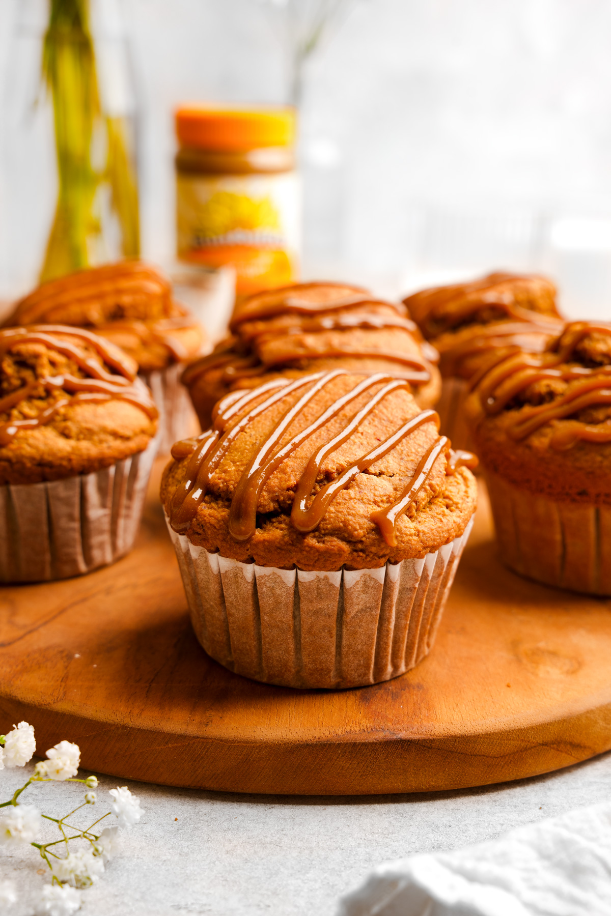 the sunbuttter muffins on a plate topped with the maple glaze