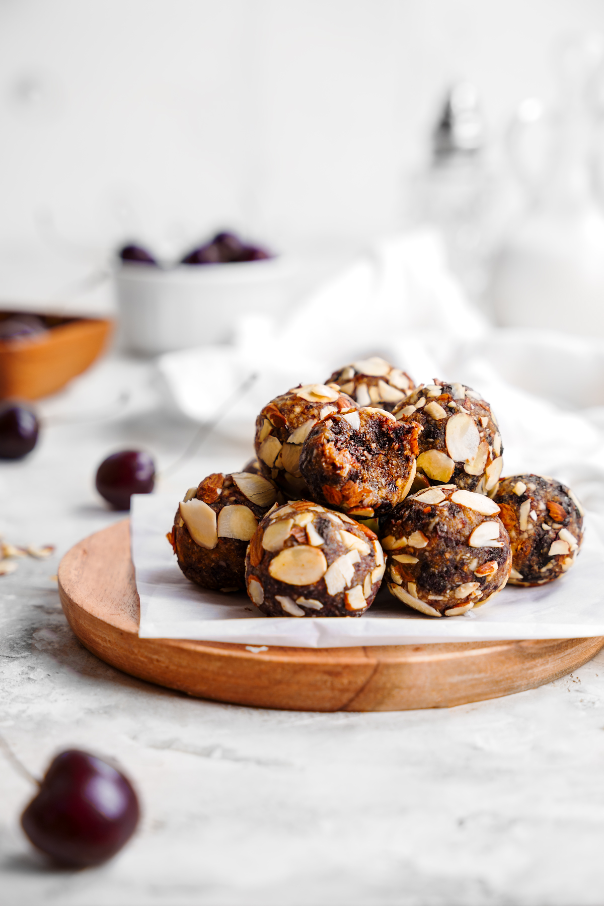 a plate of the cherry balls with a bite taken out of one to show the soft and chewy texture