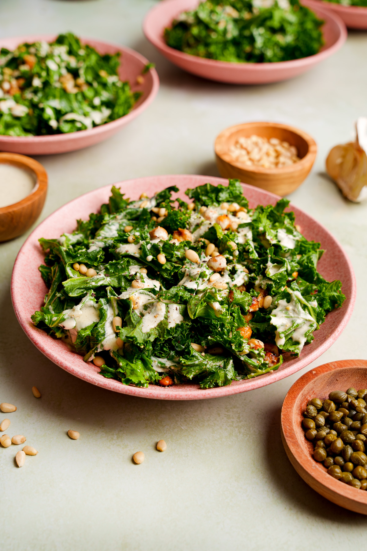 a bowl of the roasted chickpea caesar salad with small bowls of the ingredients around it