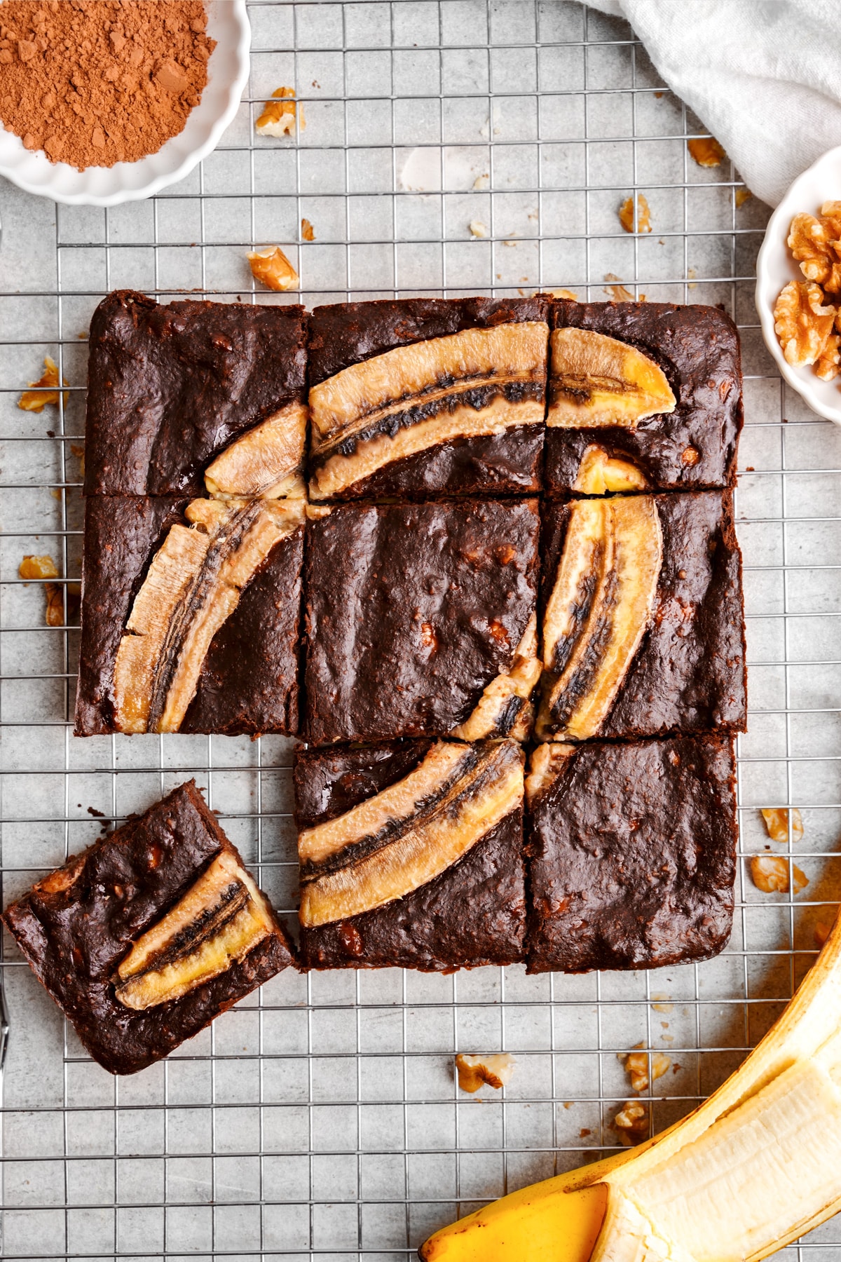 looking down at the 3 ingredient banana brownies cut into squares with two baked bananas on top