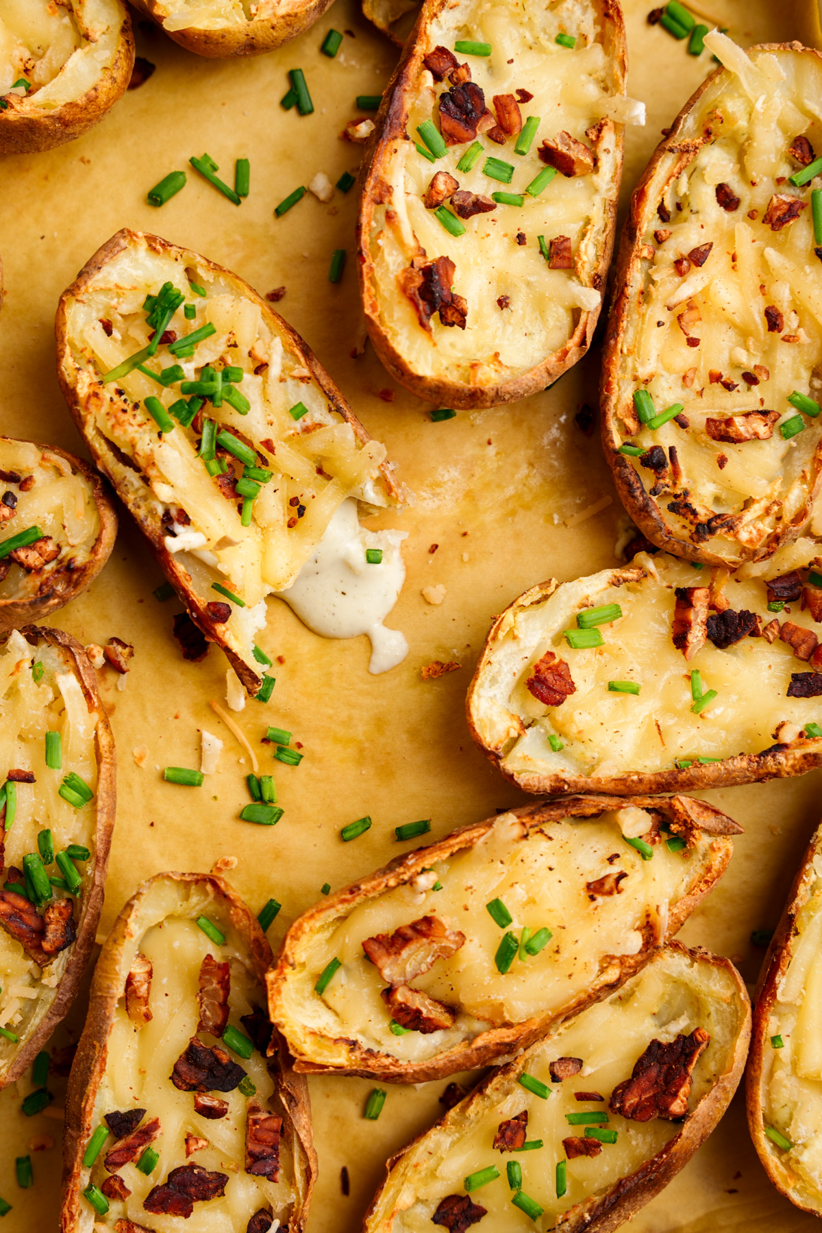 looking down at the vegan potato skins with a bite taken out oof one and the good foods sauce dripping out of it