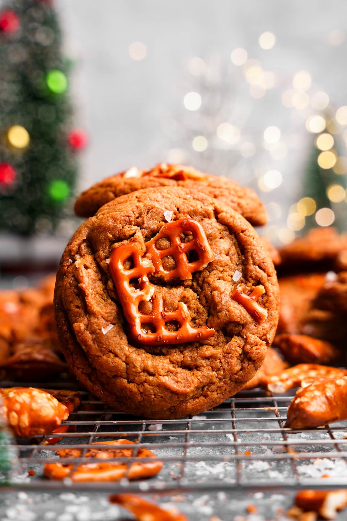 a close up of the peanut butter pretzel cookies with peanut butter nuggets and pretzels around it