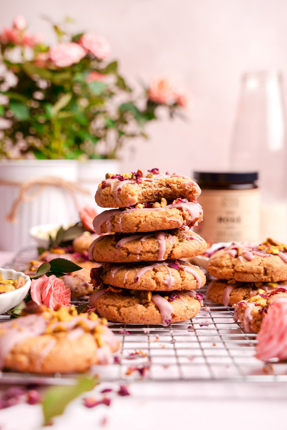 the rose cookies stacked on top of each other next to the anima mundi rose powder with a bite taken out of one