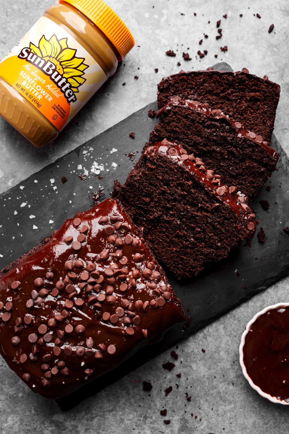 looking down at slices chocolate loaf cake with the sunbutter container text to it