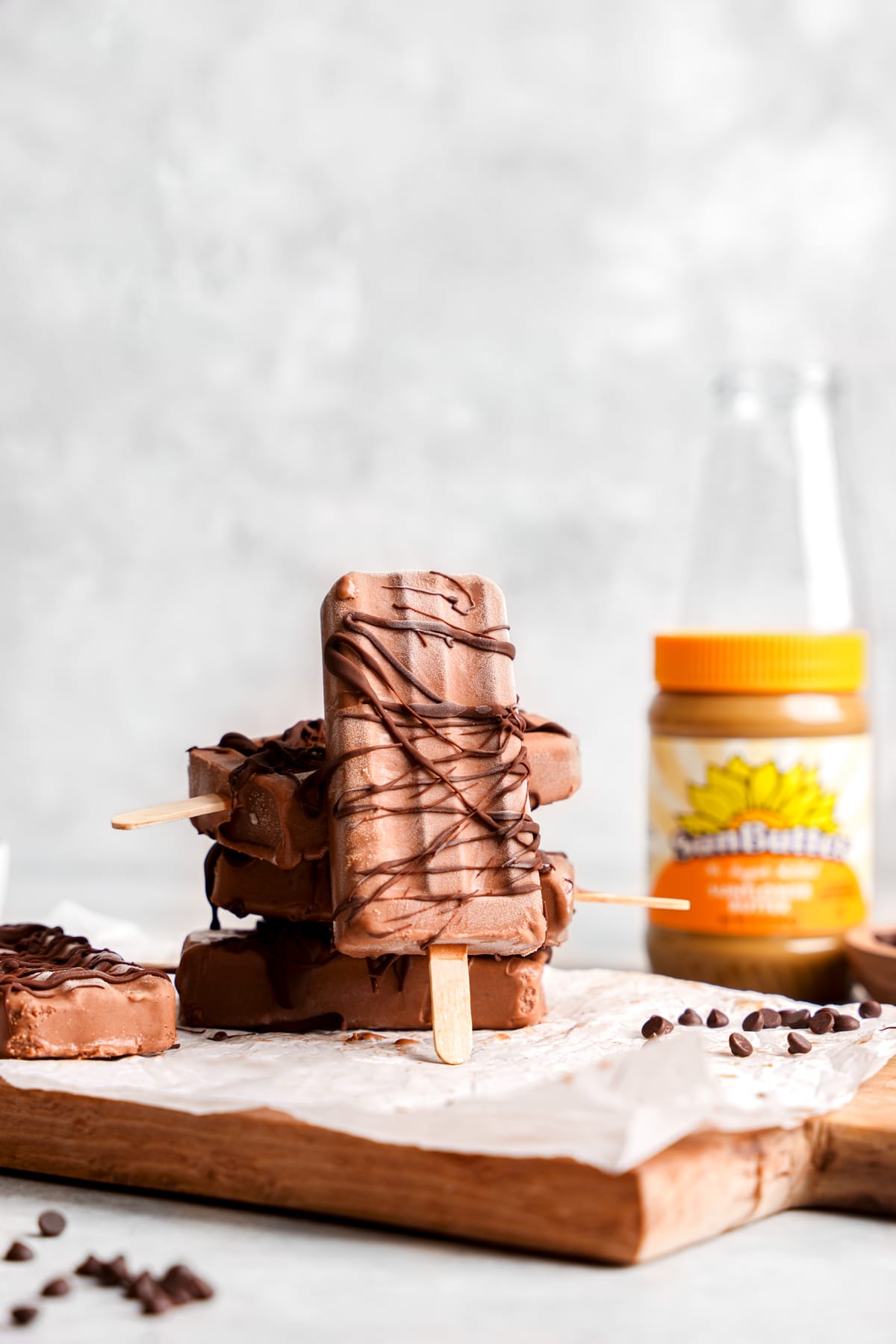 the vegan fudgesicle stacked up against the others with the sunbutter in the background