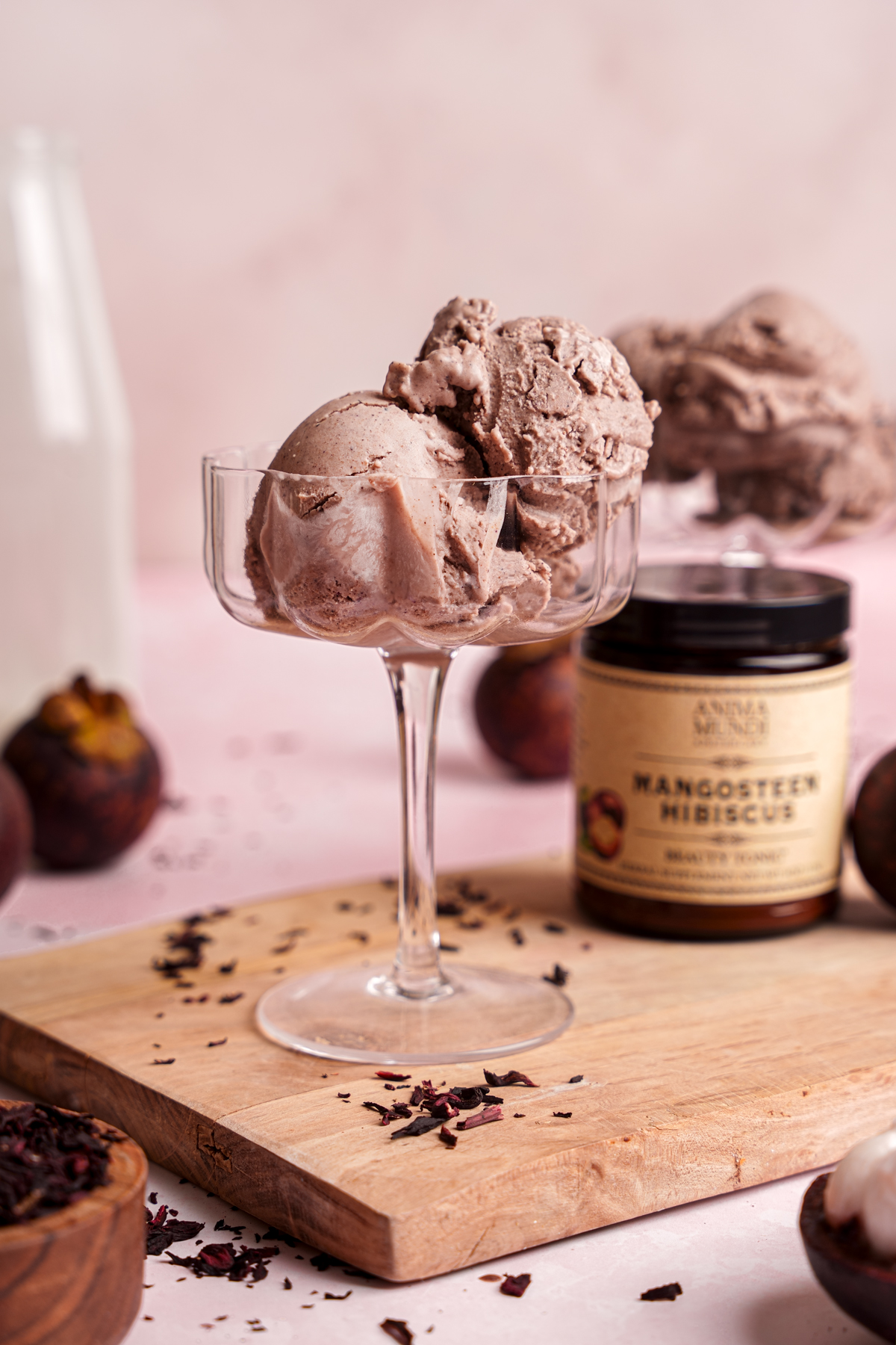 a close up of the mangosteen hibiscus ice cream with the anima mundi powder next to it