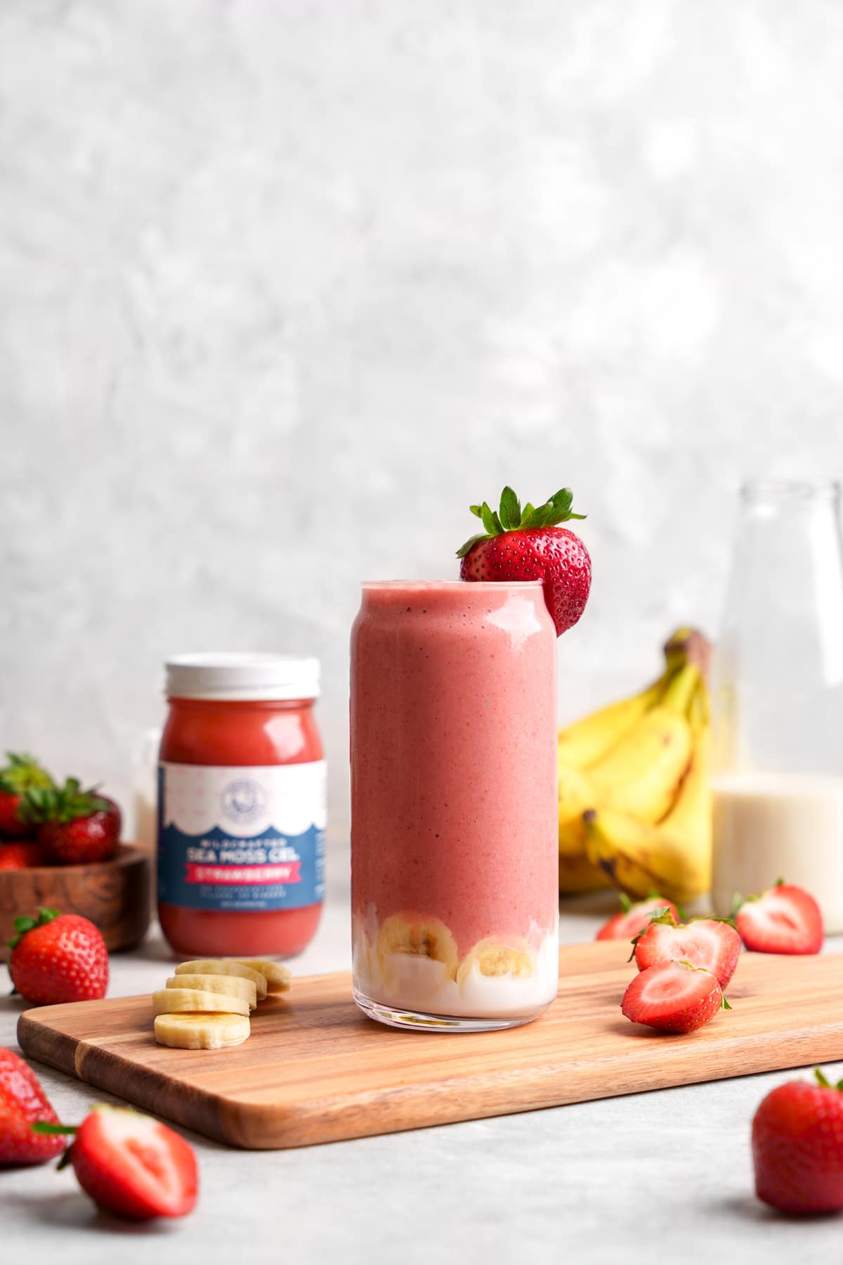 the sea moss smoothie with fresh strawberries and bananas around it