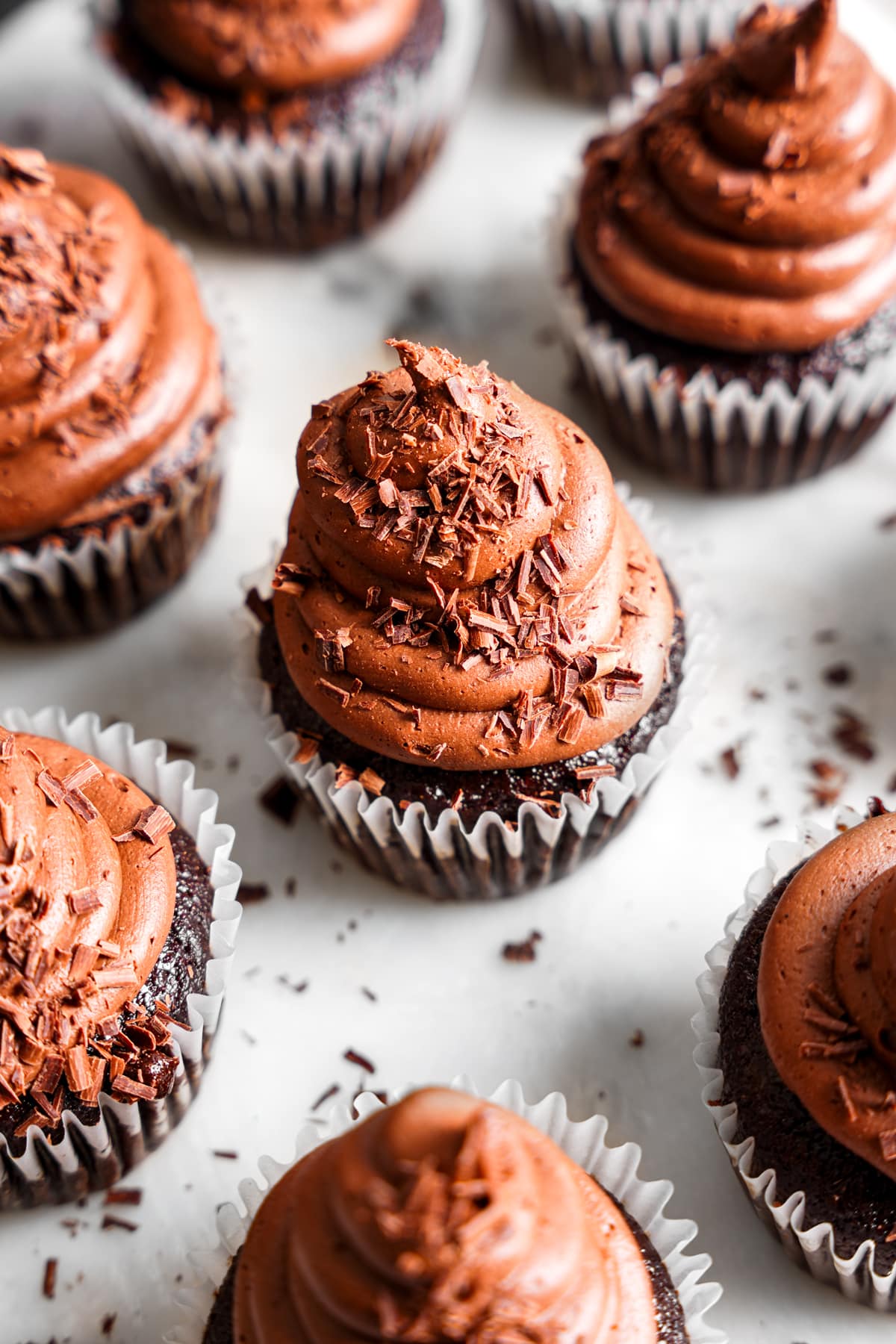 looking down at the vegan chocolate cupcakes with chocolate shavings on top of the mousse frosting