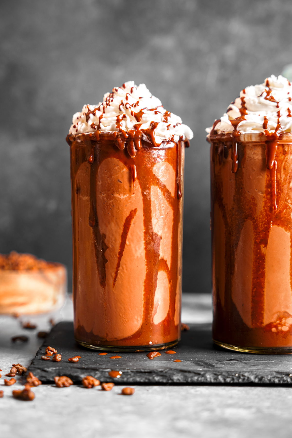 a close up of the hazelnut frappe with whipped cream on top and chocolate hazelnut dripping from the glass
