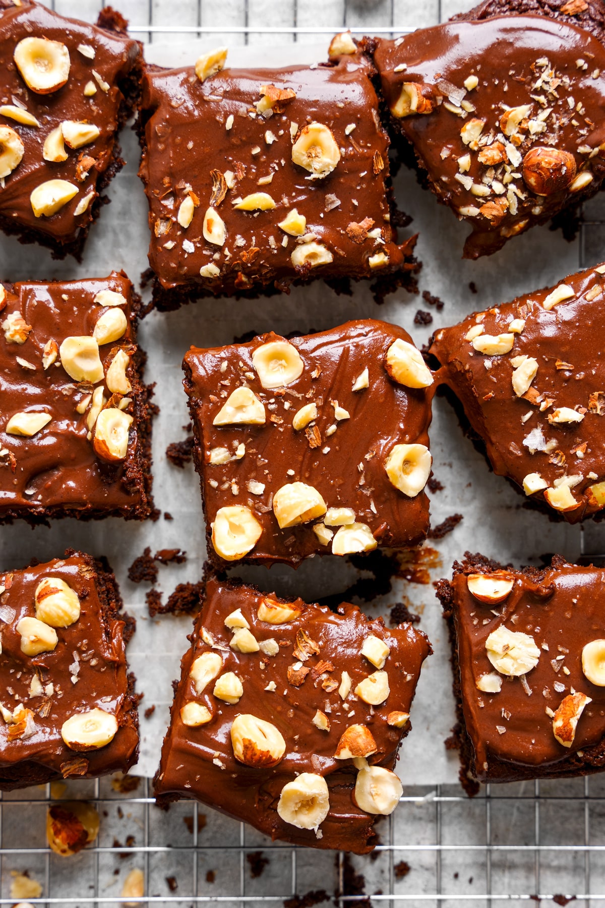 looking down at the chocolate hazelnut brownies with raw hazelnuts sprinkled on top of the chocolate ganache