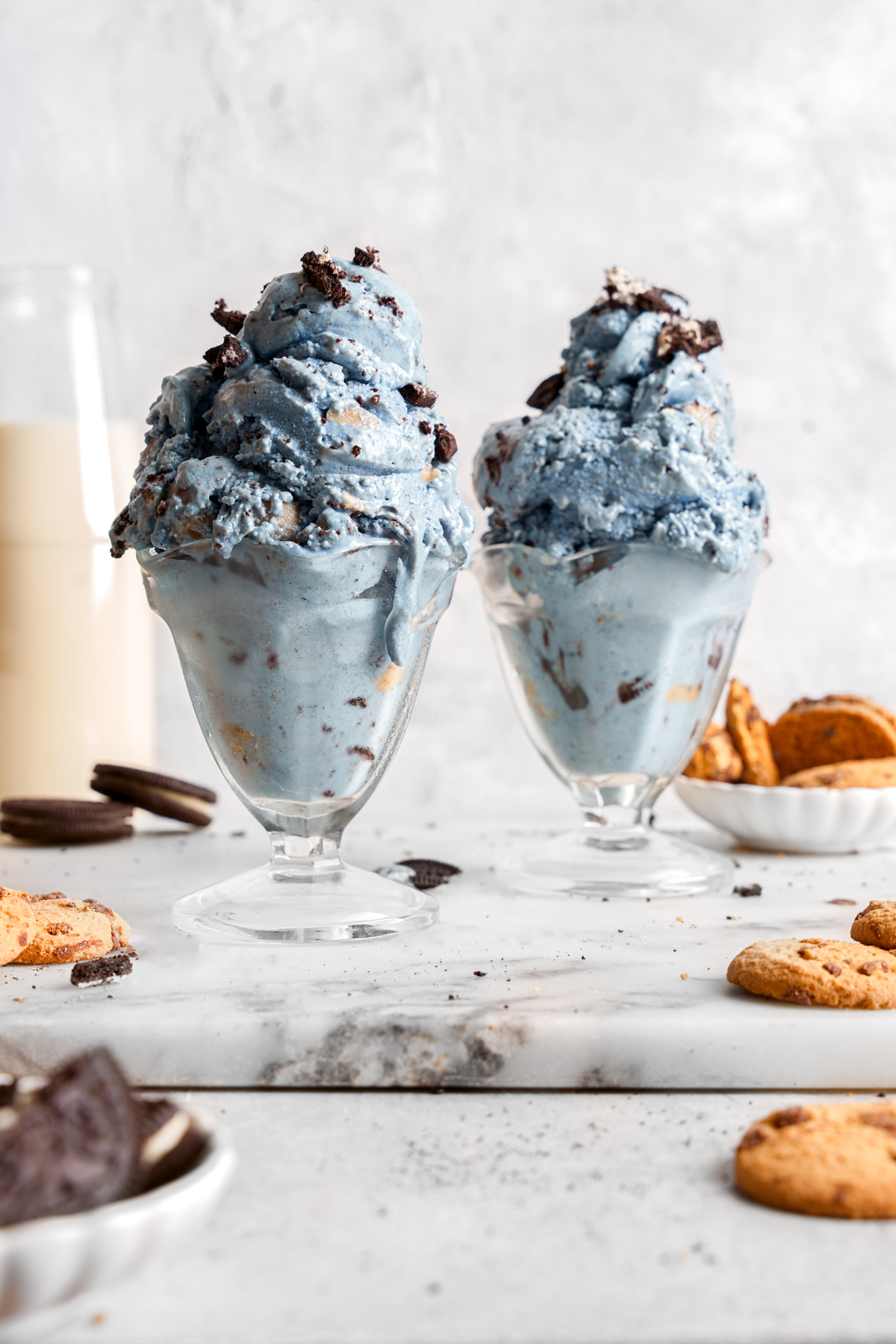 the cookie monster ice cream in ice cream dishes with cookies all around them