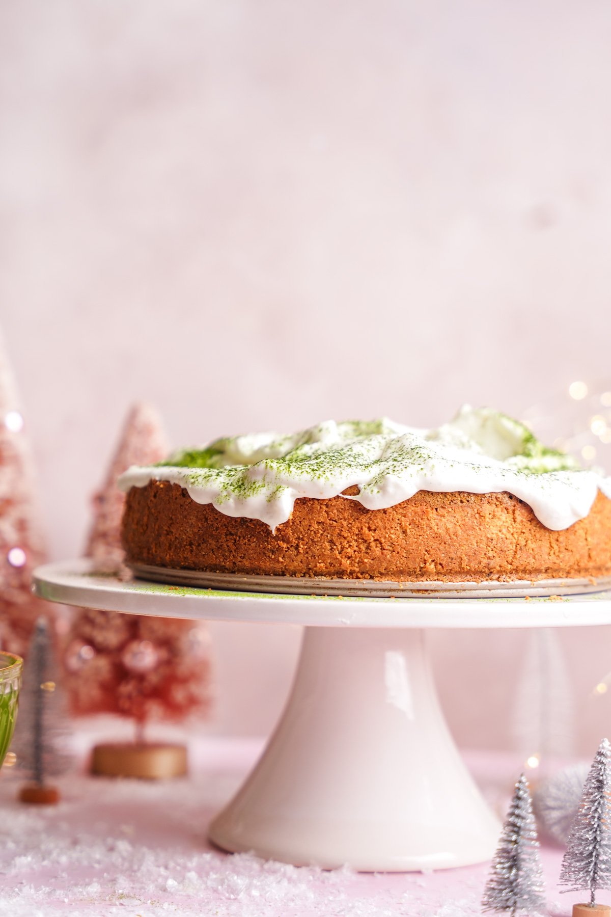 the vegan matcha cheesecake on a cake stand