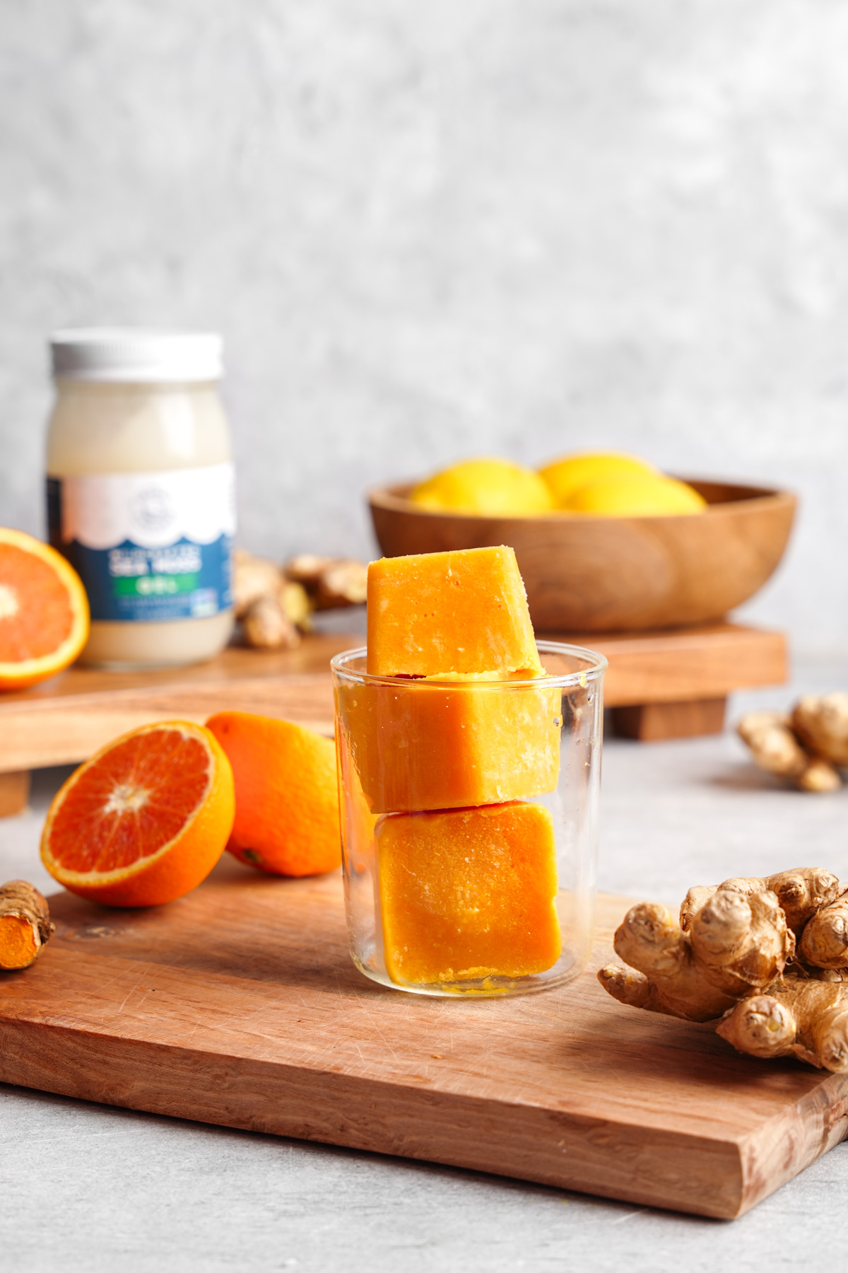 the immunity cubes stacked in a glass with all the fresh ingredients around it