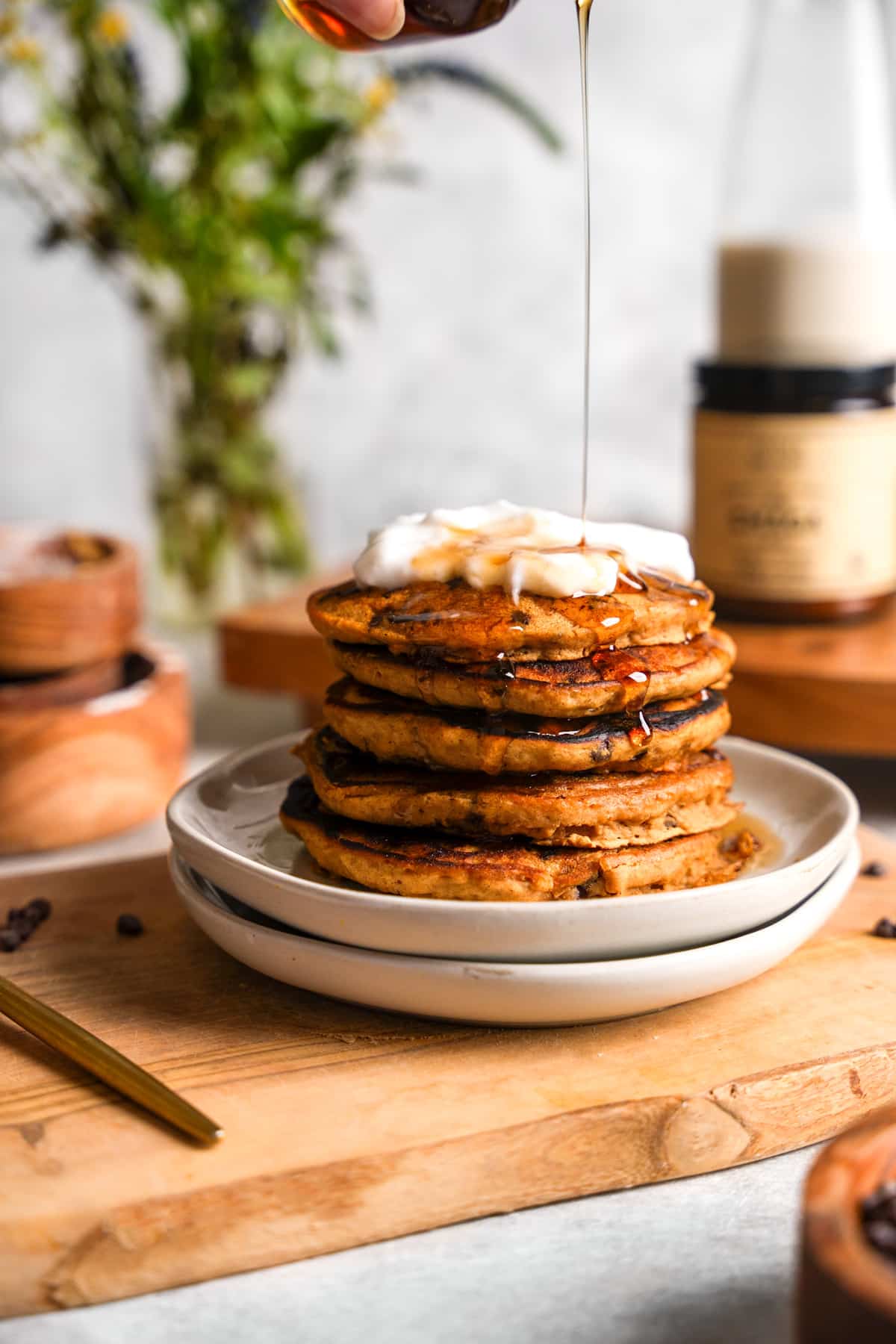pouring maple syrup on top of the chaga mushroom pancakes