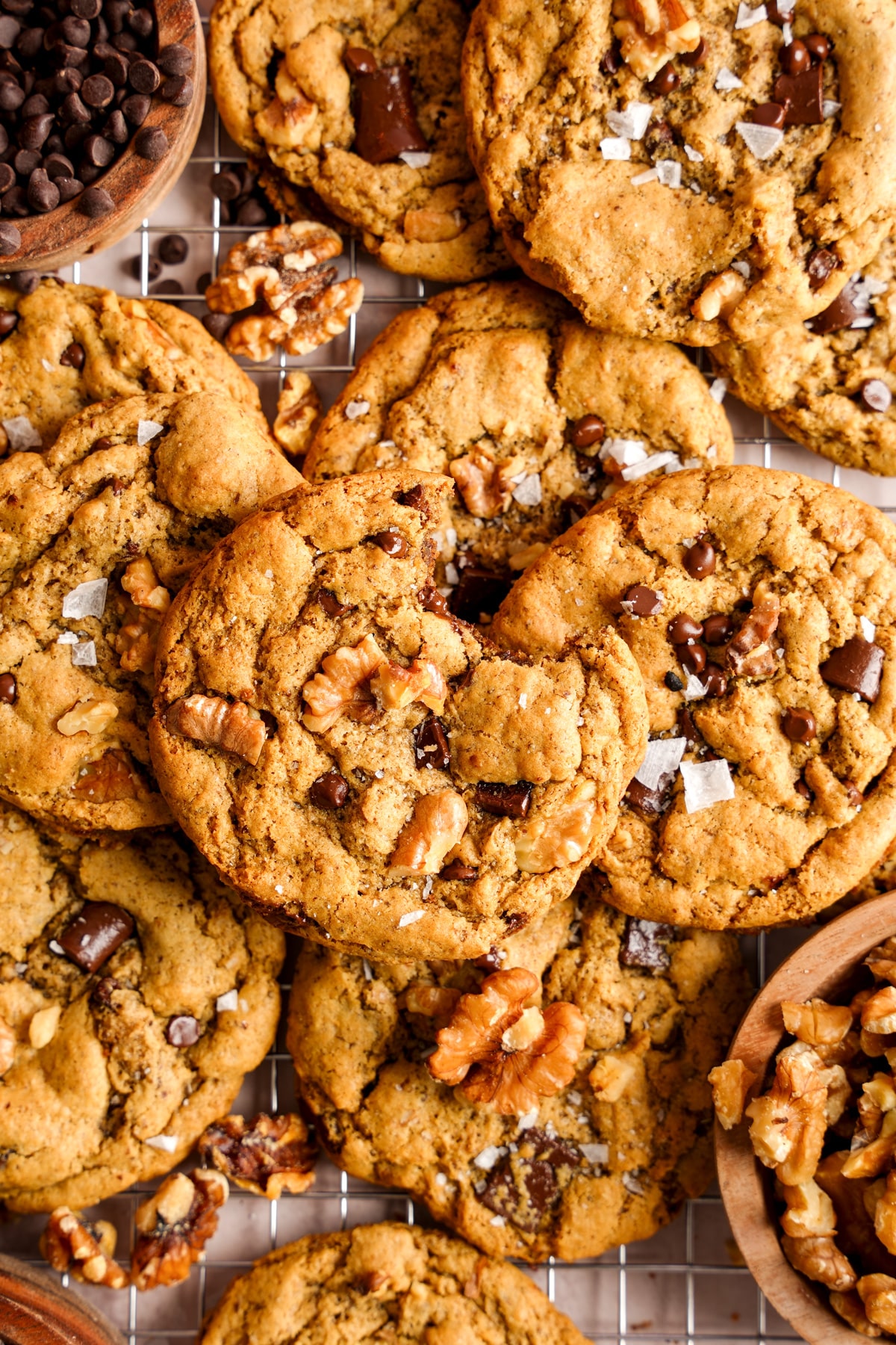 the chocolate chip walnut cookies on a cooling rack with a bite taken out of one