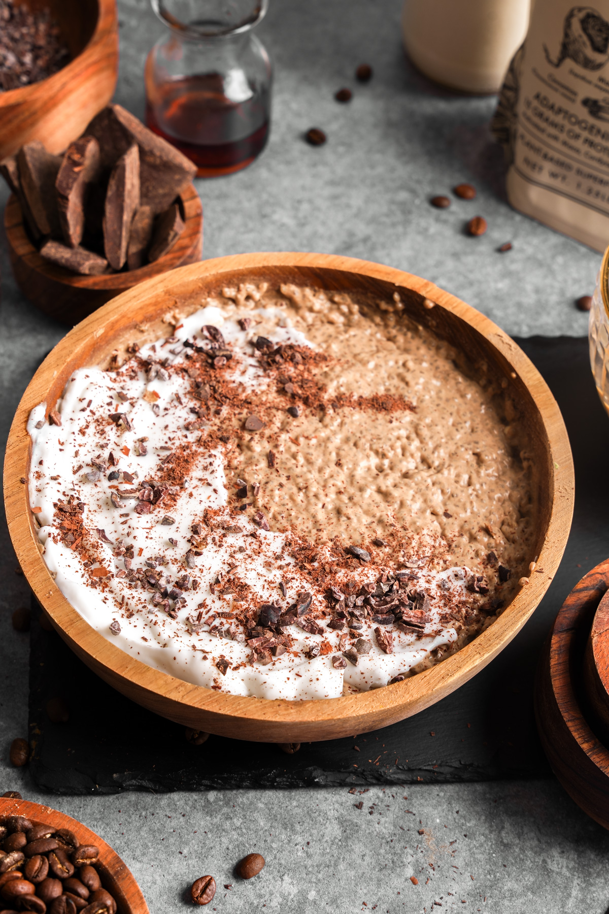 the coffee protein chia seed pudding  in a bowl with coconut yogurt and chocolate on top