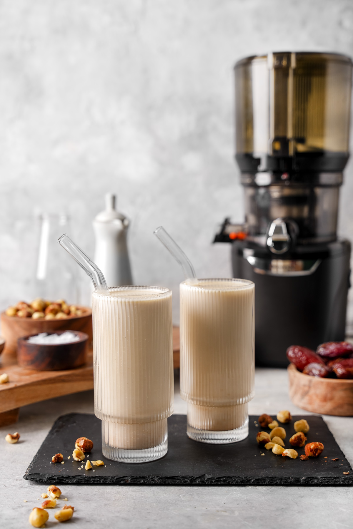 glasses of the hazelnut milk next to the kuvings AUTO10 plus juicer