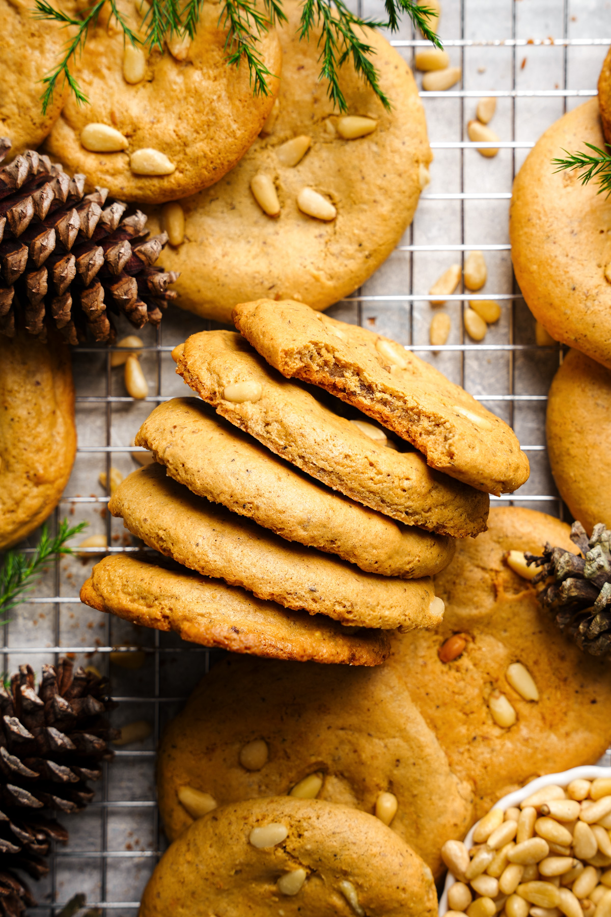 the pine nut cookies stacked on top of each other with a bite taken out of the top one