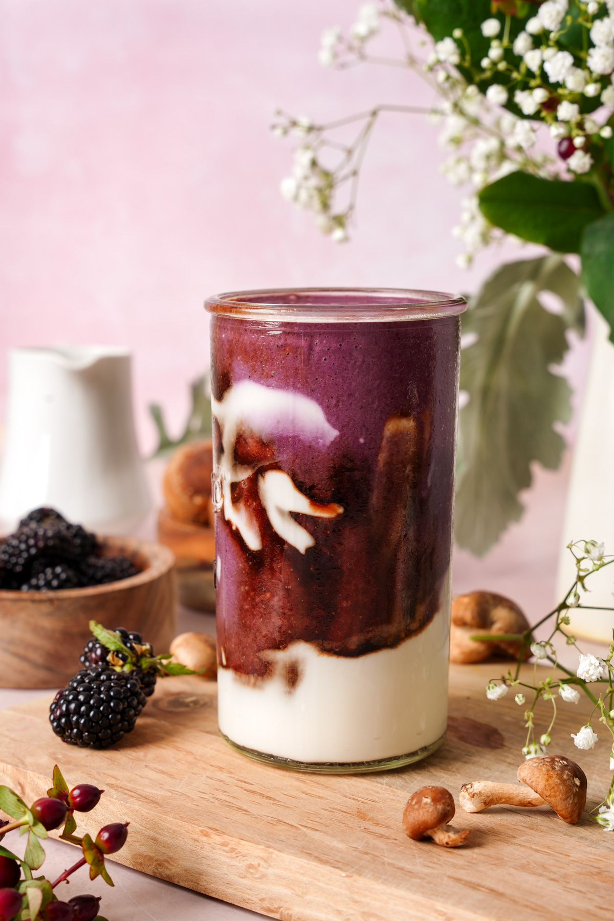 the elderberry smoothie in a glass showing all the layers of the smoothie