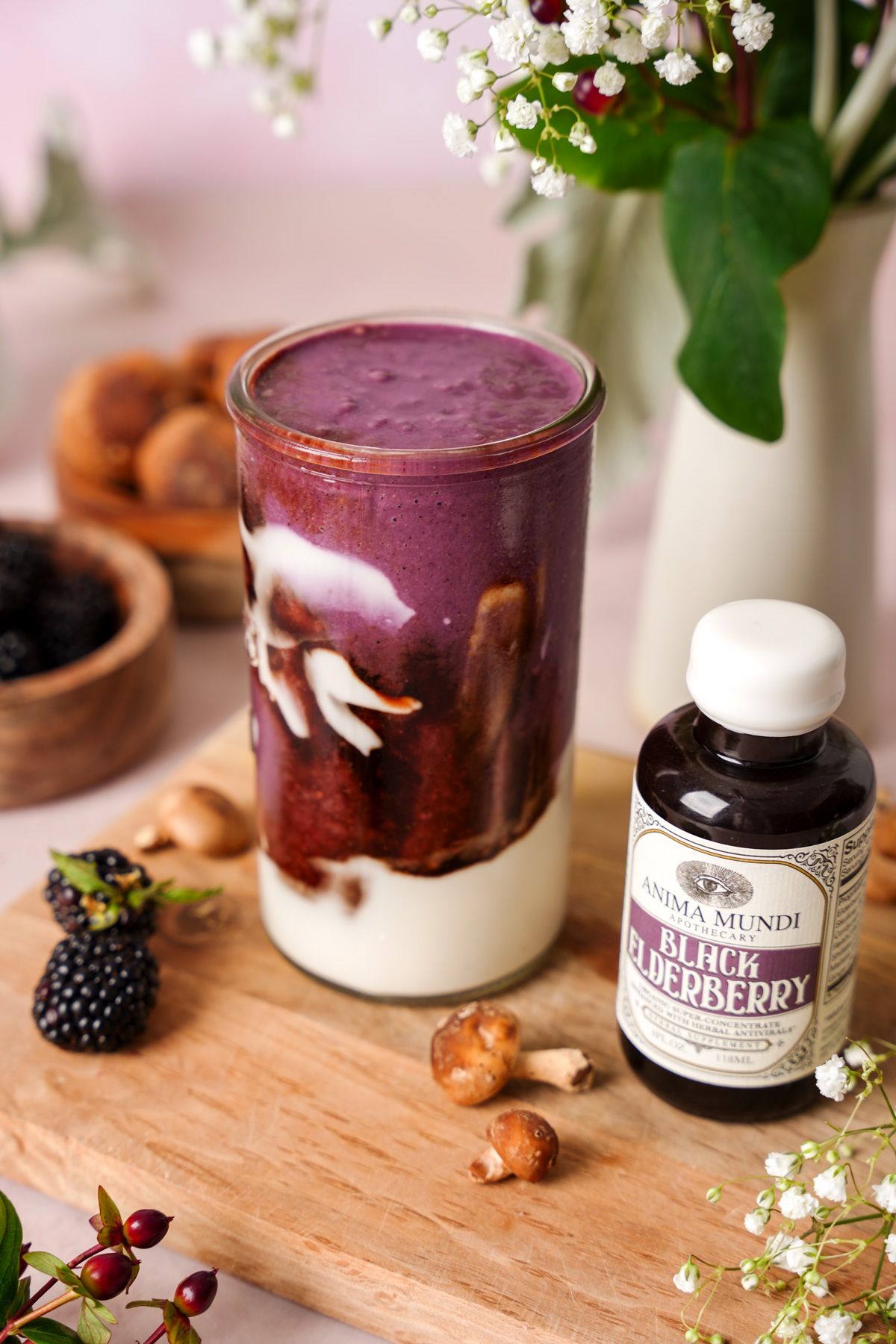 the immunity smoothie next to the black elderberry elixir from anima mundi to show the layers and creamy texture