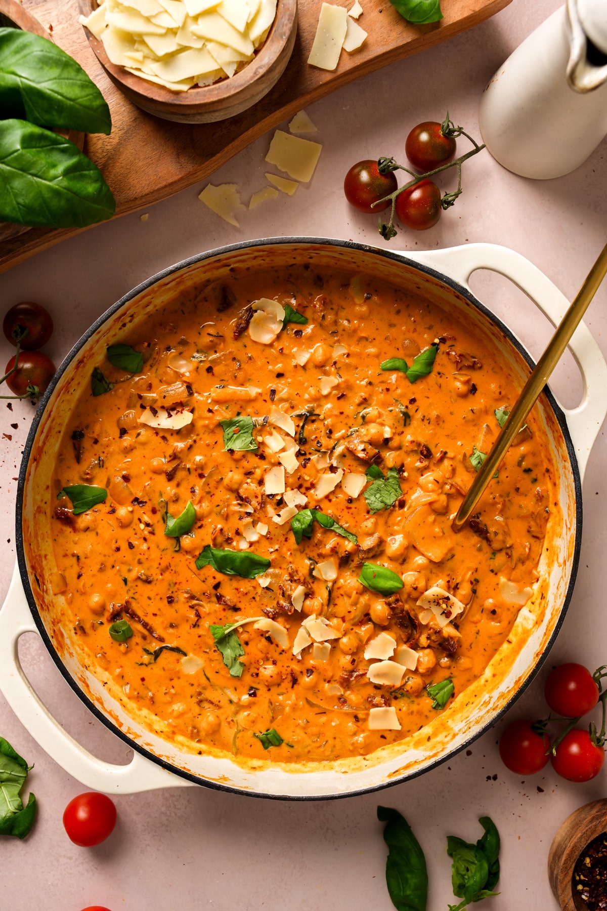 the marry me chickpeas in a pot topped with fresh basil and vegan parmesan