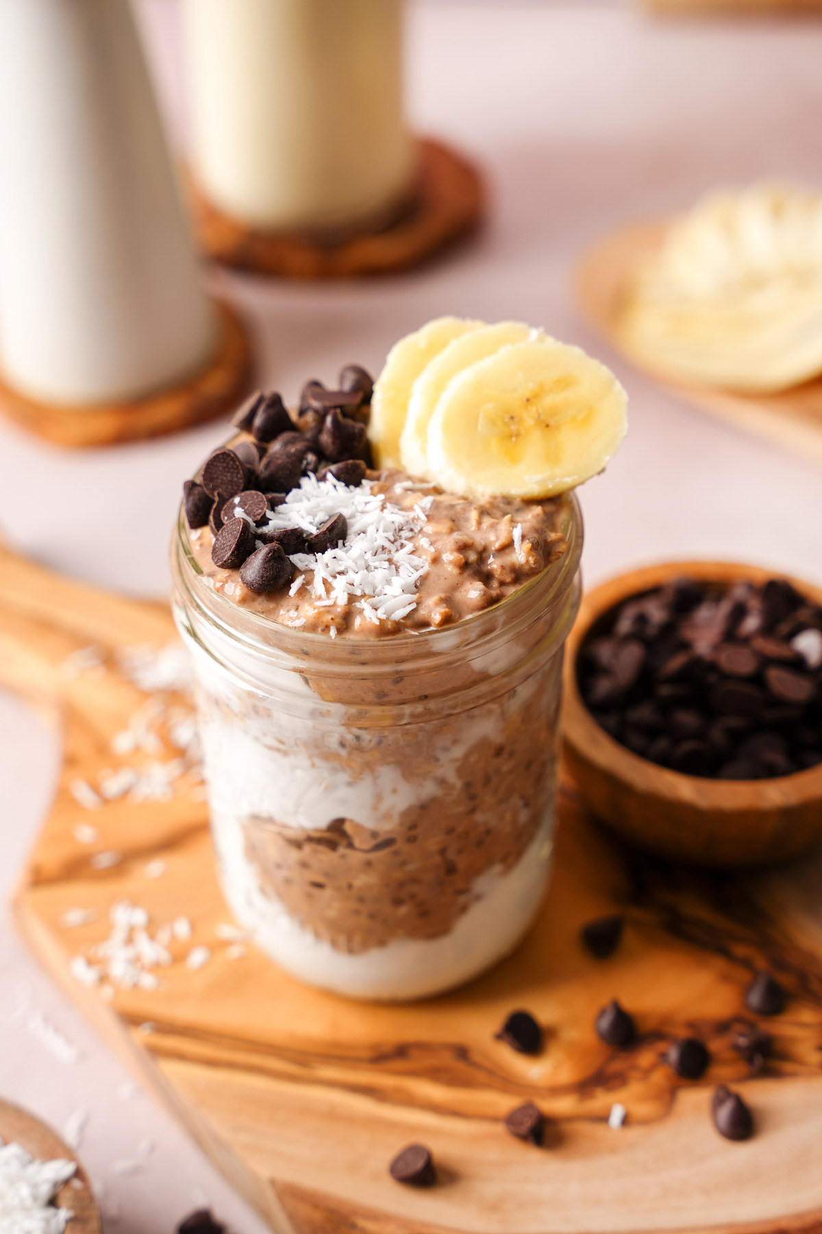 the creamy chocolate overnight oats topped with chocolate chips, coconut, and banana