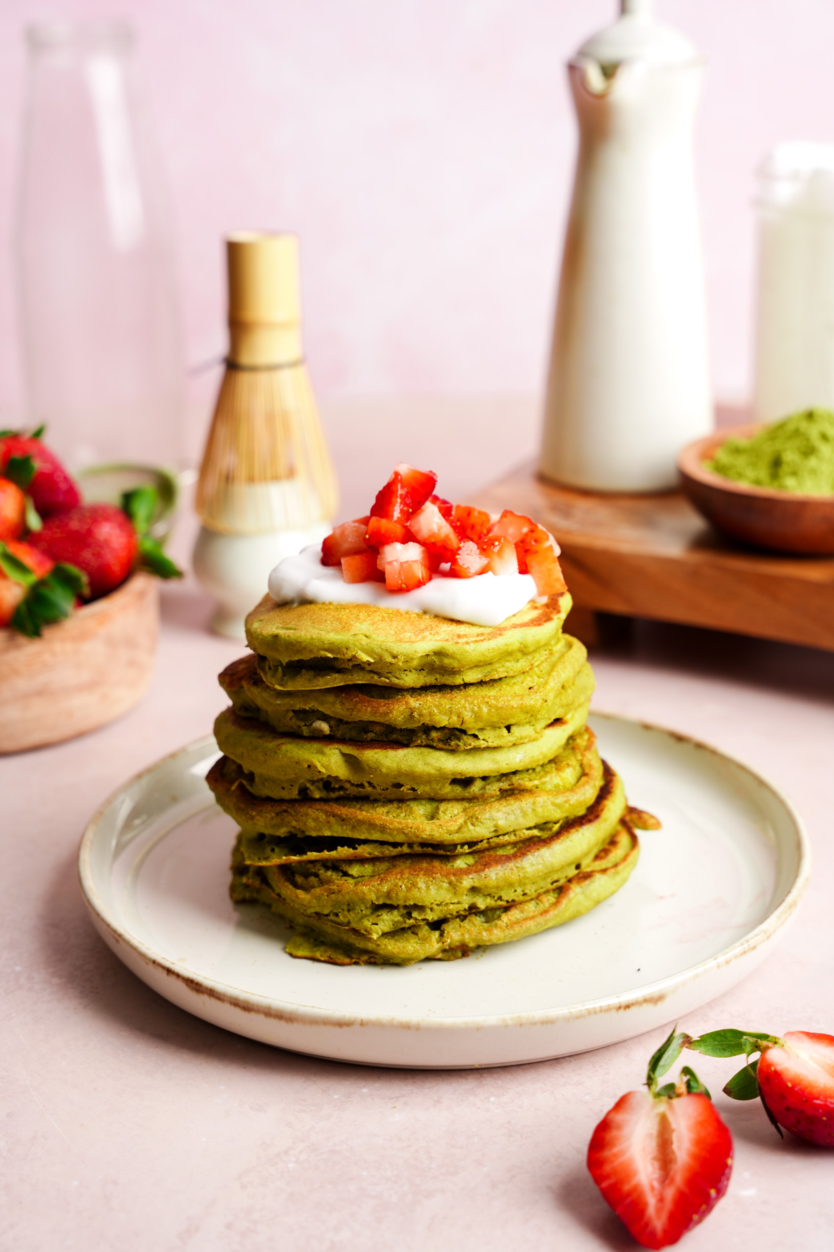 the vegan matcha pancakes topped with coconut yogurt and fresh strawberries