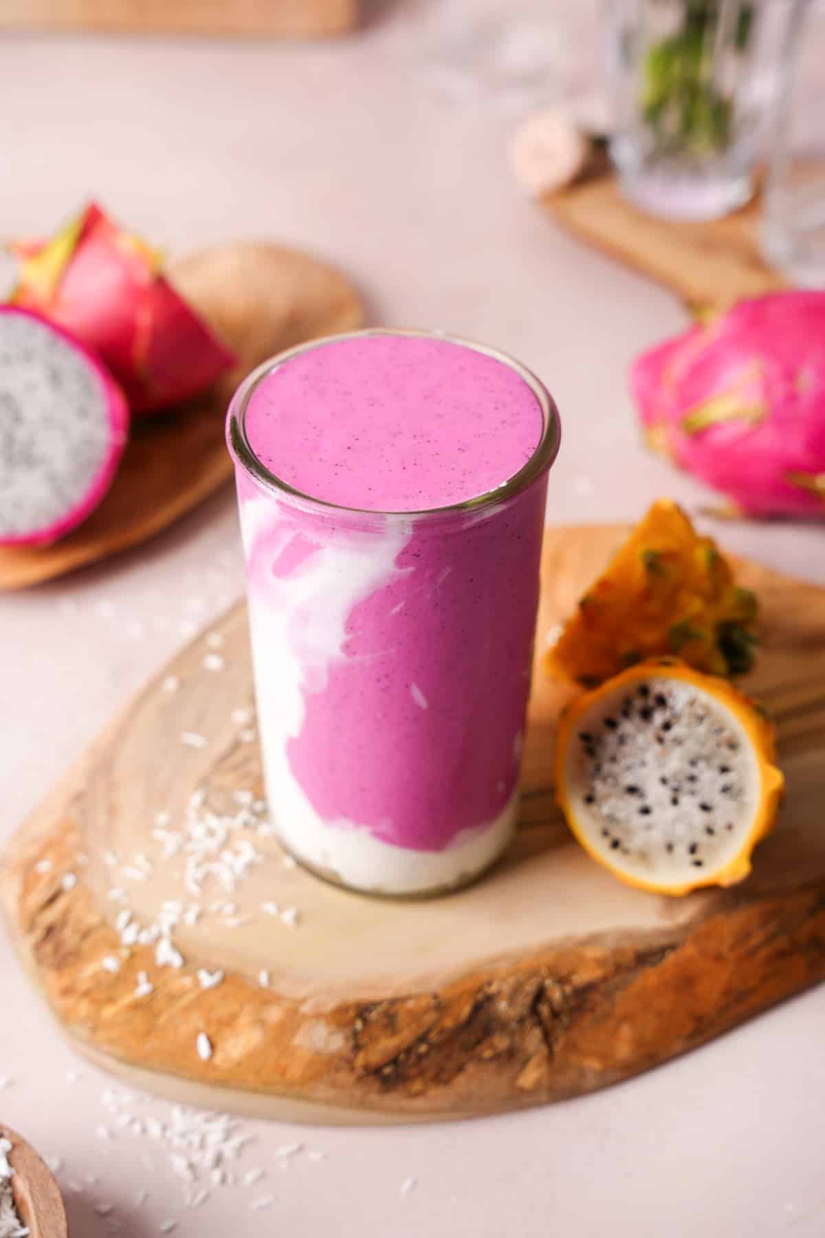 looking down at the pink dragon fruit smoothie with fresh dragon fruit around it