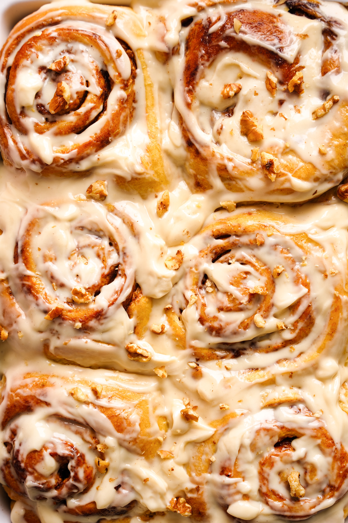 a close up of the carrot cake cinnamon rolls with the cream cheese icing on top